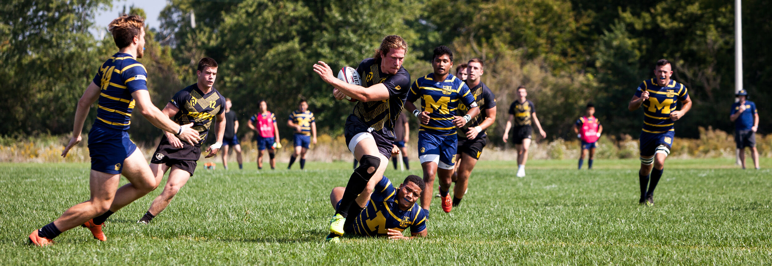  A member of the University of Iowa’s Men’s Rugby Team powers though an attempted tackle during a rugby match against the University of Michigan on Friday, Sep. 23, 2016. 