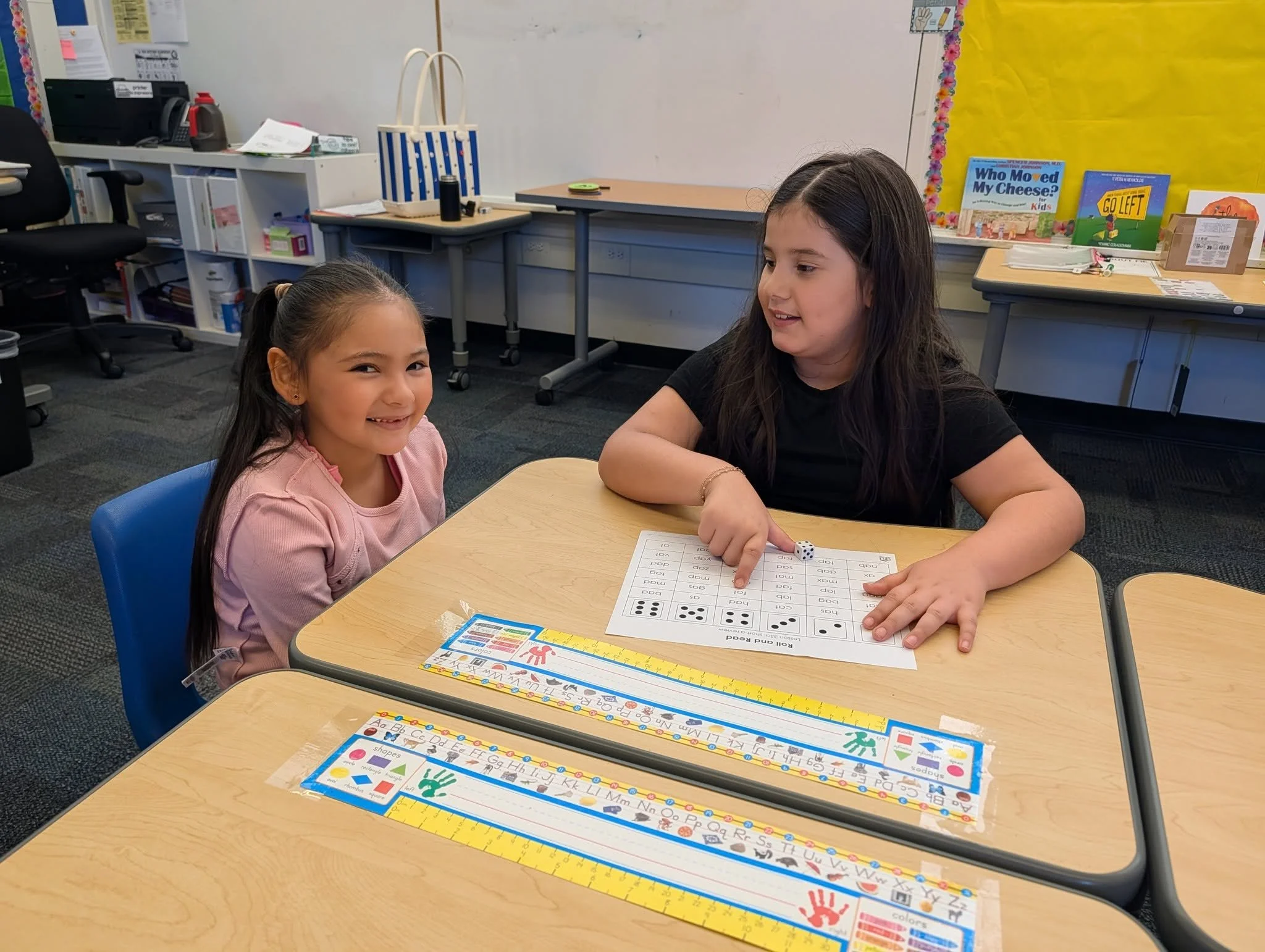 Two students practice sight words together using a worksheet.