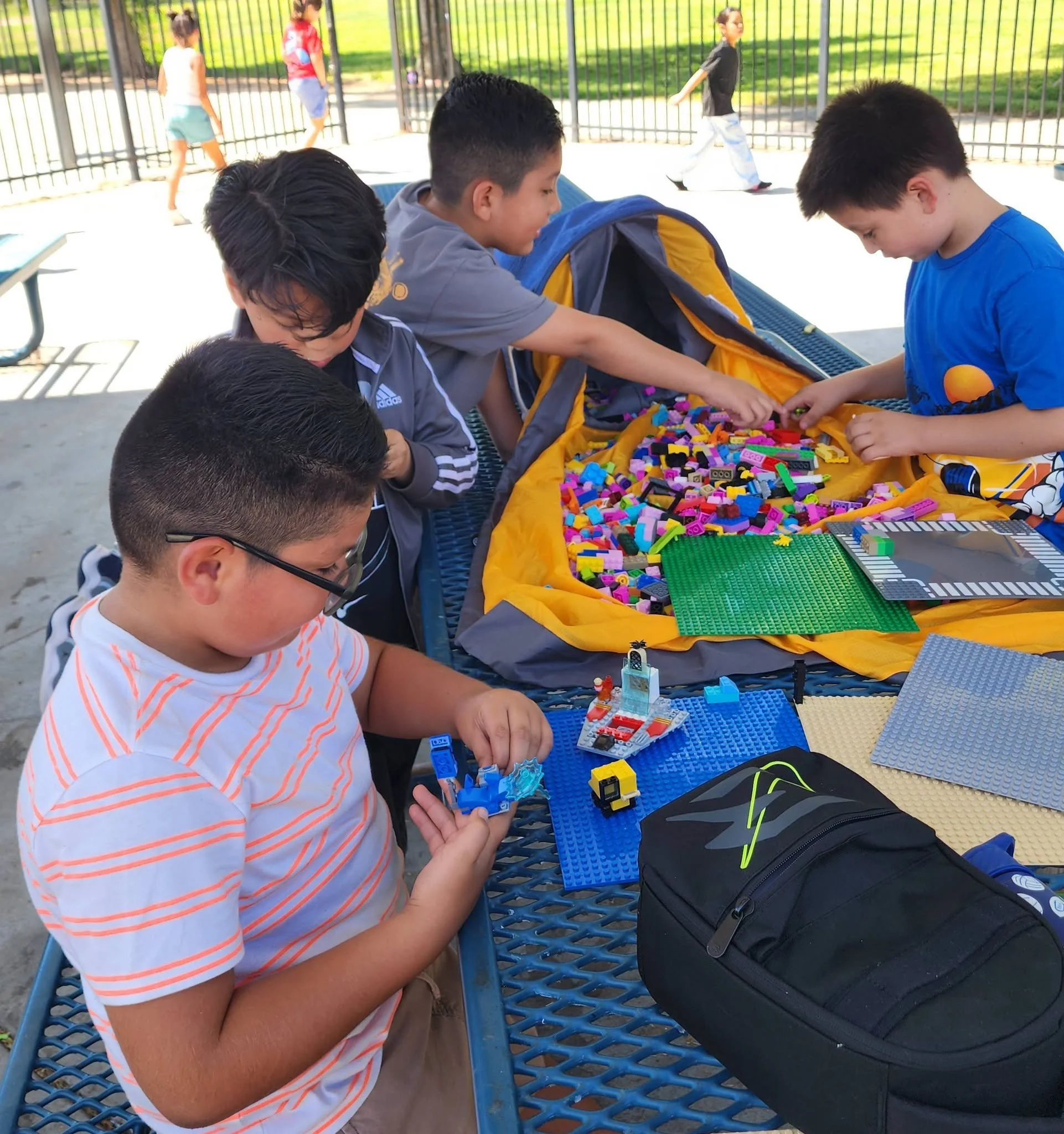 Students build Lego models on baseplates during lunch.