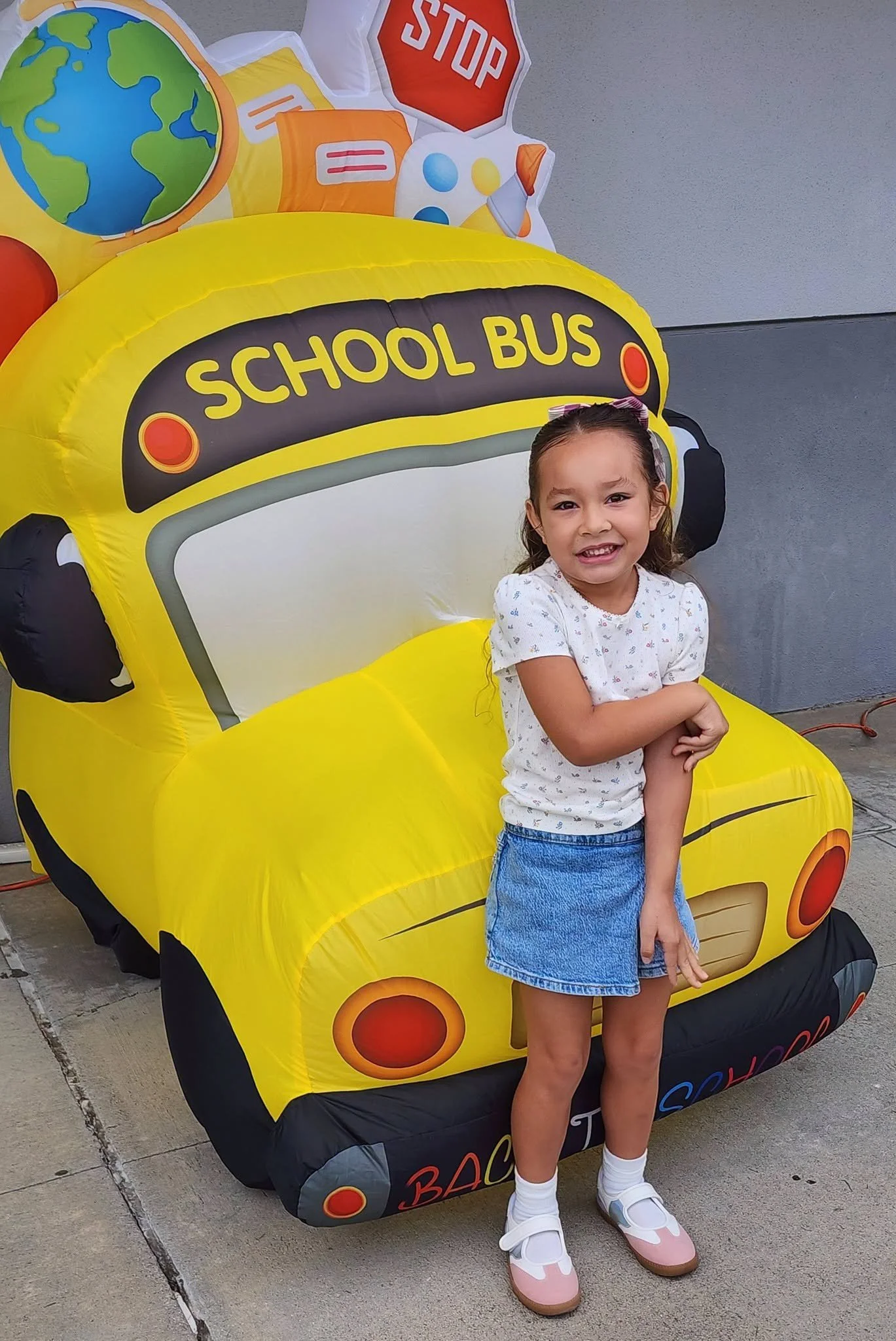 A student smiles beside the yellow school-bus decoration.