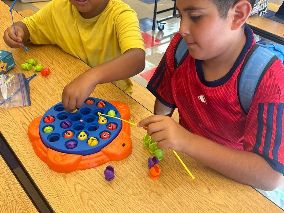 Two children play a fishing board game together.