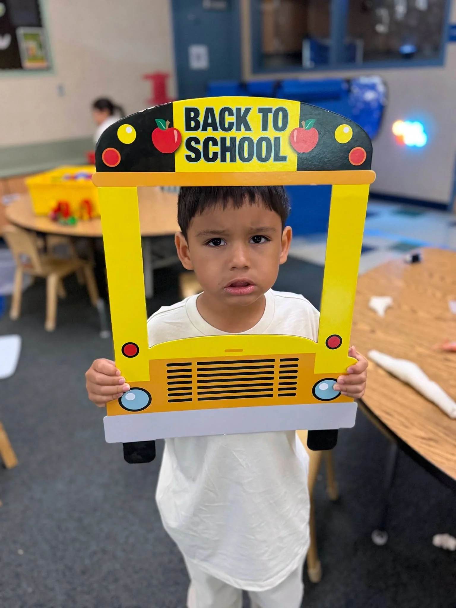 A student holds the back-to-school photo frame in the classroom.