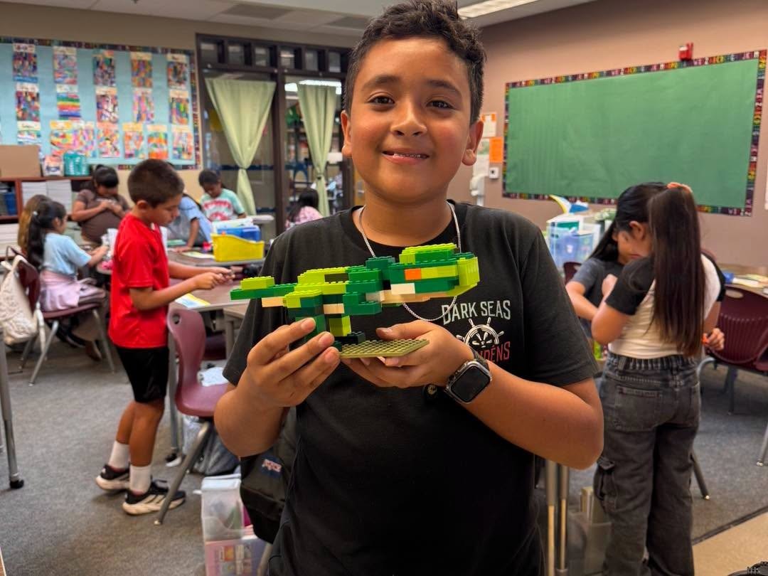 A student uses colorful LEGO bricks to create a model.