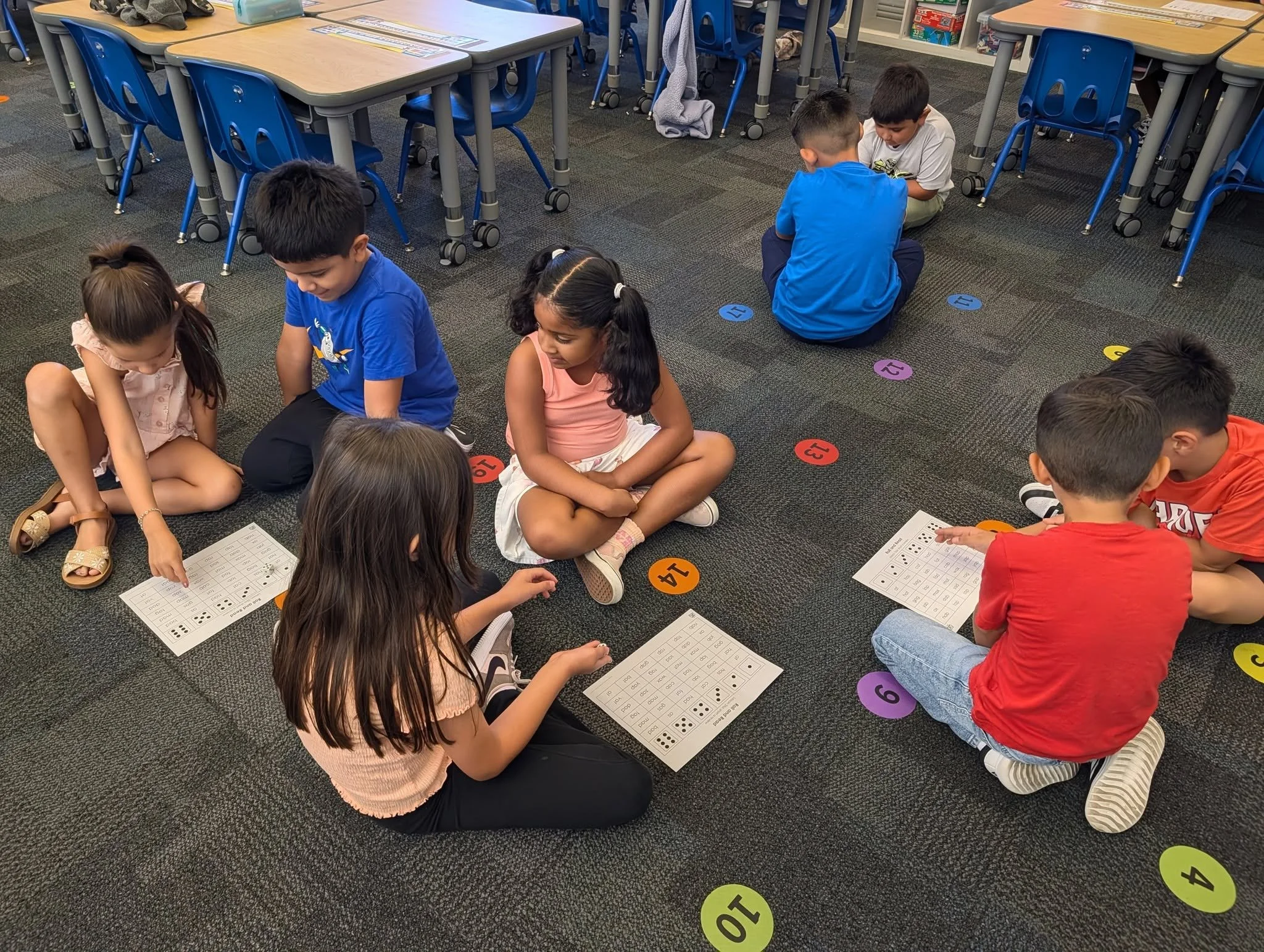 Students work in pairs on sight-word activities on the classroom rug.