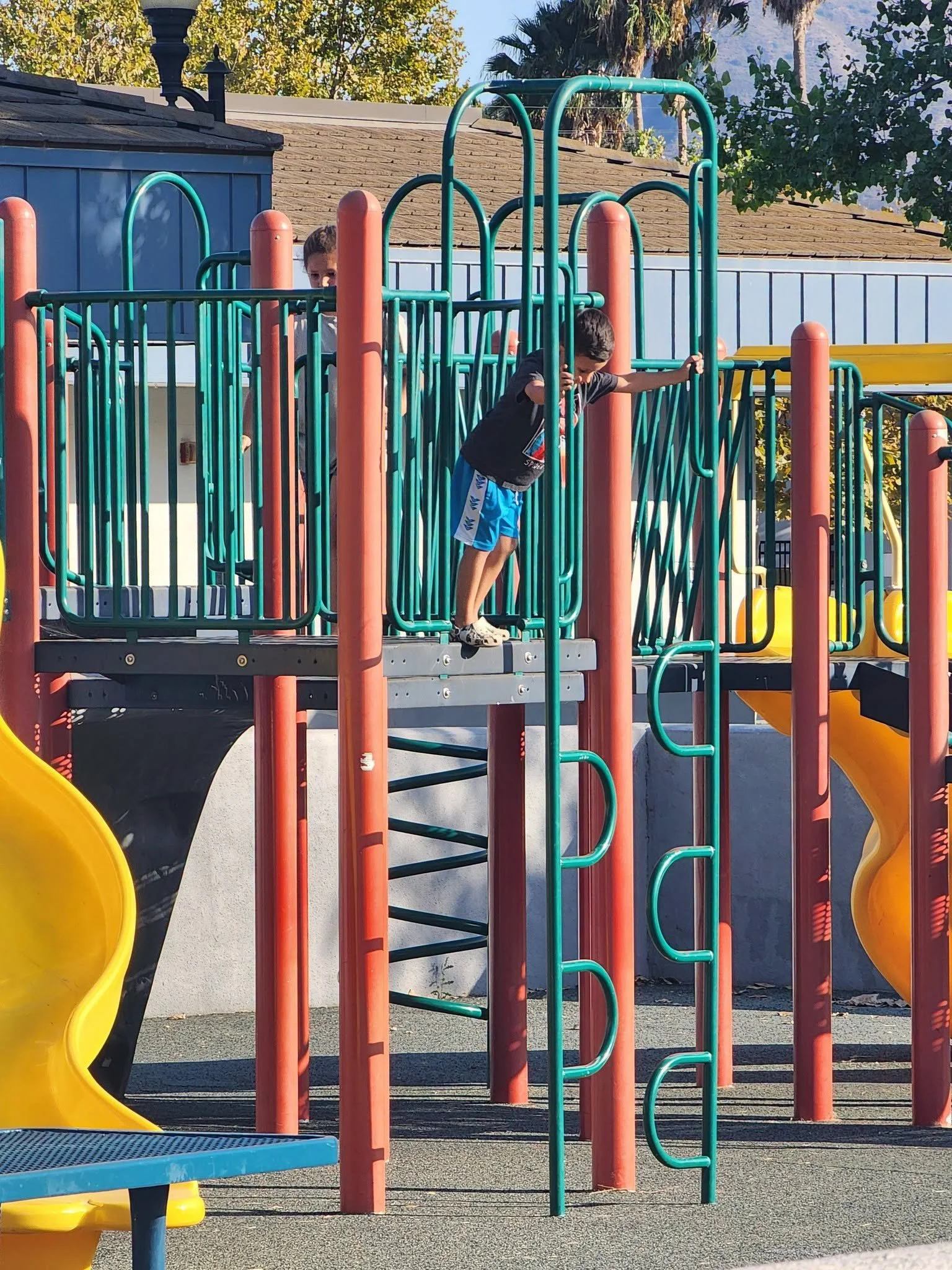 A child explores climbing equipment on the Mountain Vista playground.