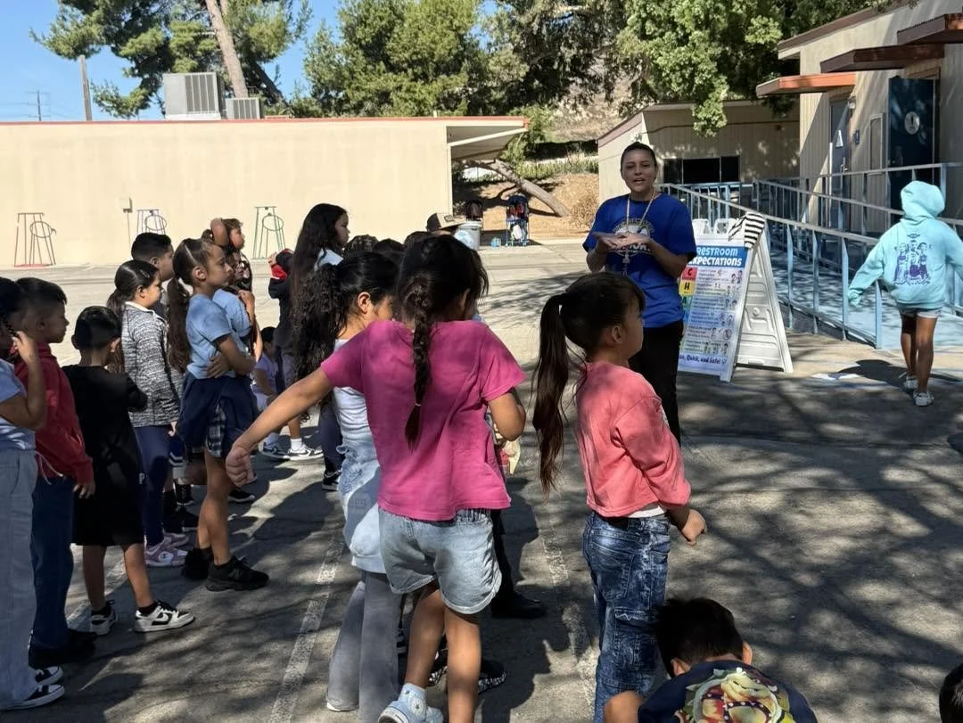 A staff member reviews restroom expectations with students outside.