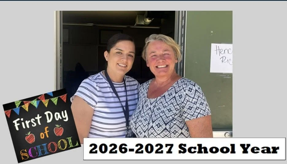 Two Sierra High staff members smile at a classroom doorway.