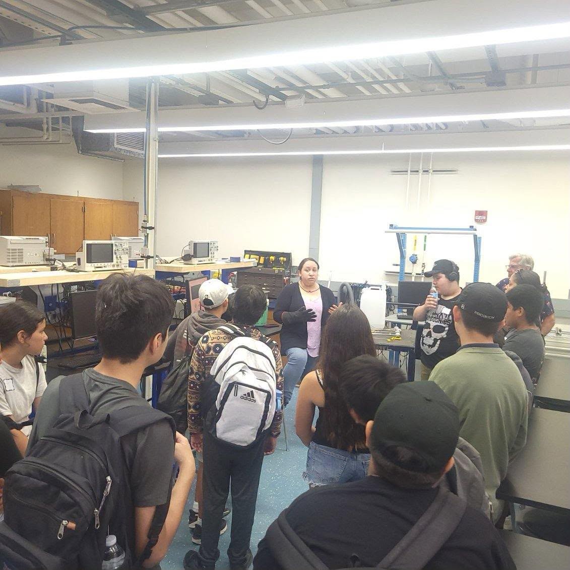 Students listen to a presenter during a tour of a laboratory classroom.