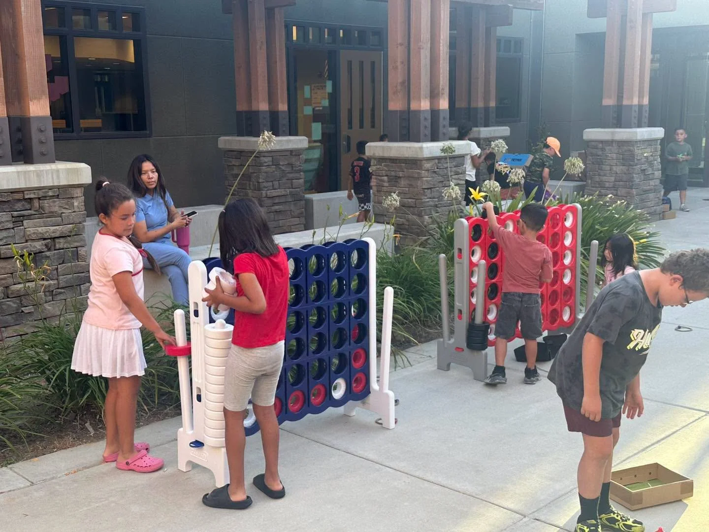 Children play oversized Connect Four games outside Rio Vista.
