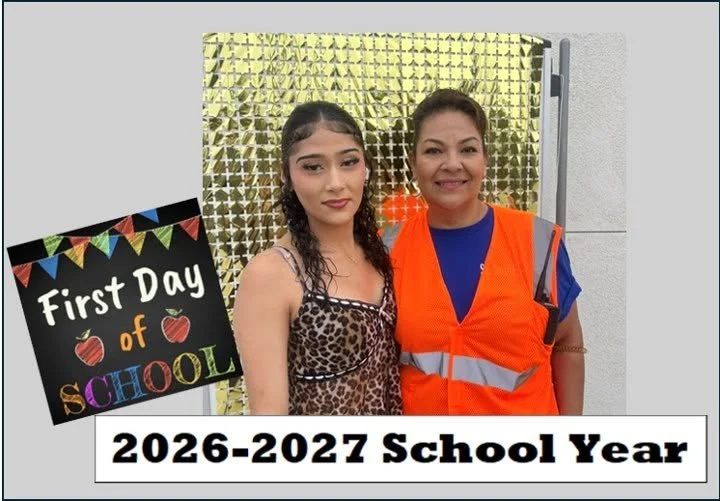 A student and an adult in a safety vest pose for a first-day photo.