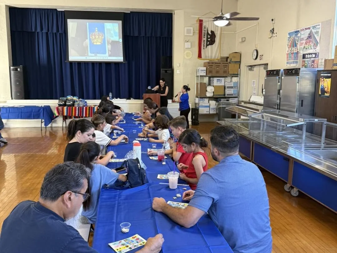 Piru Elementary families gather around a table for Lotería.