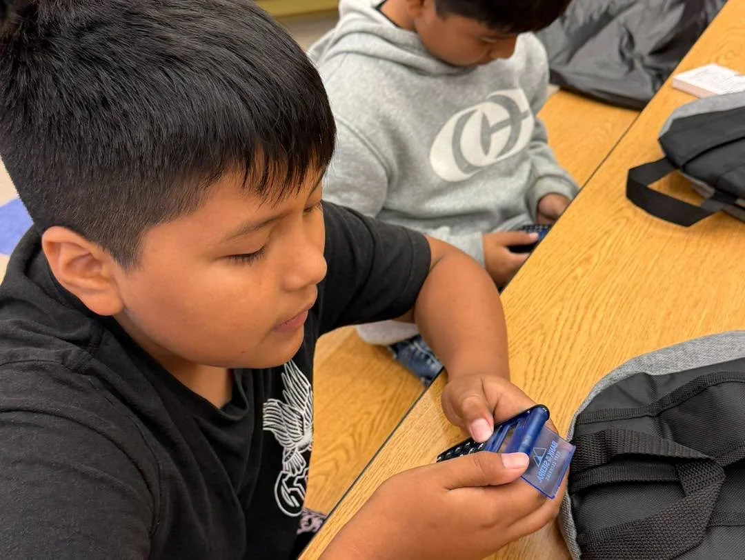 Students examine their donated calculators at a table.