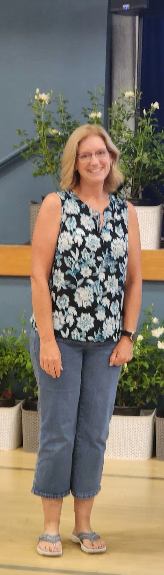 A Mountain Vista teacher smiles in a floral top during a staff-service recognition ceremony.