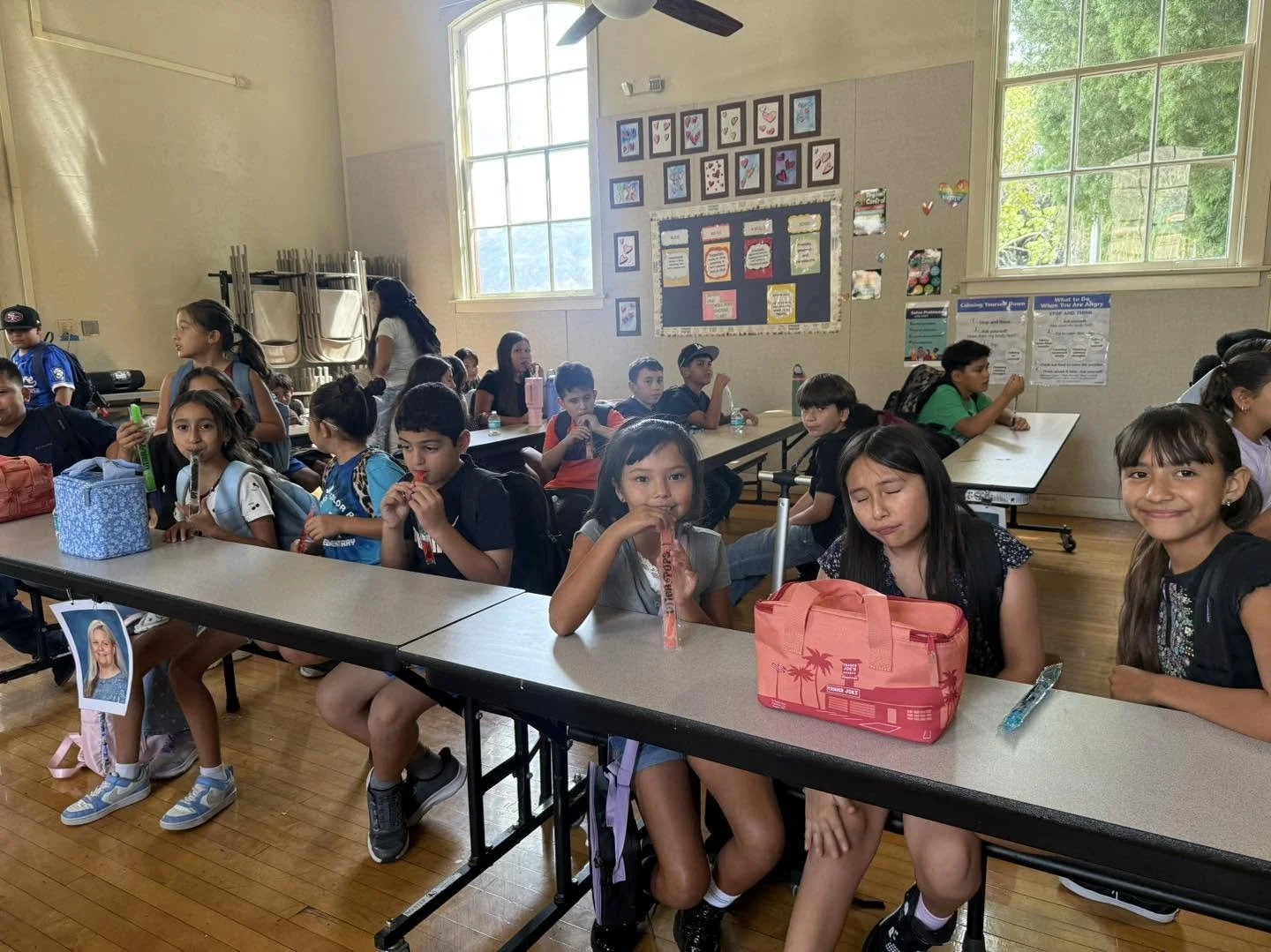 Piru students sit at cafeteria tables and enjoy cool treats during an attendance celebration.
