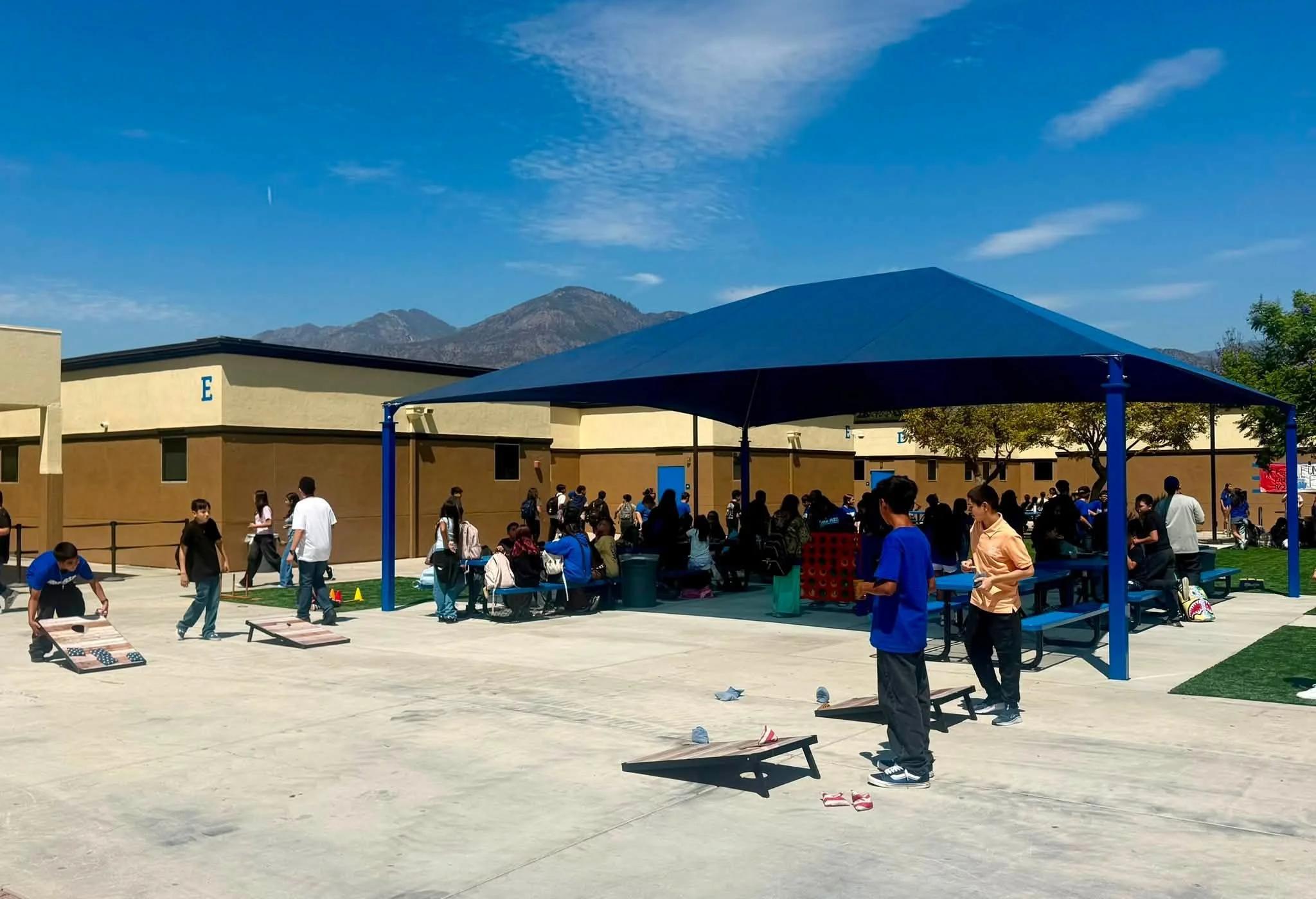 Students enjoy cornhole and other games in the school courtyard.