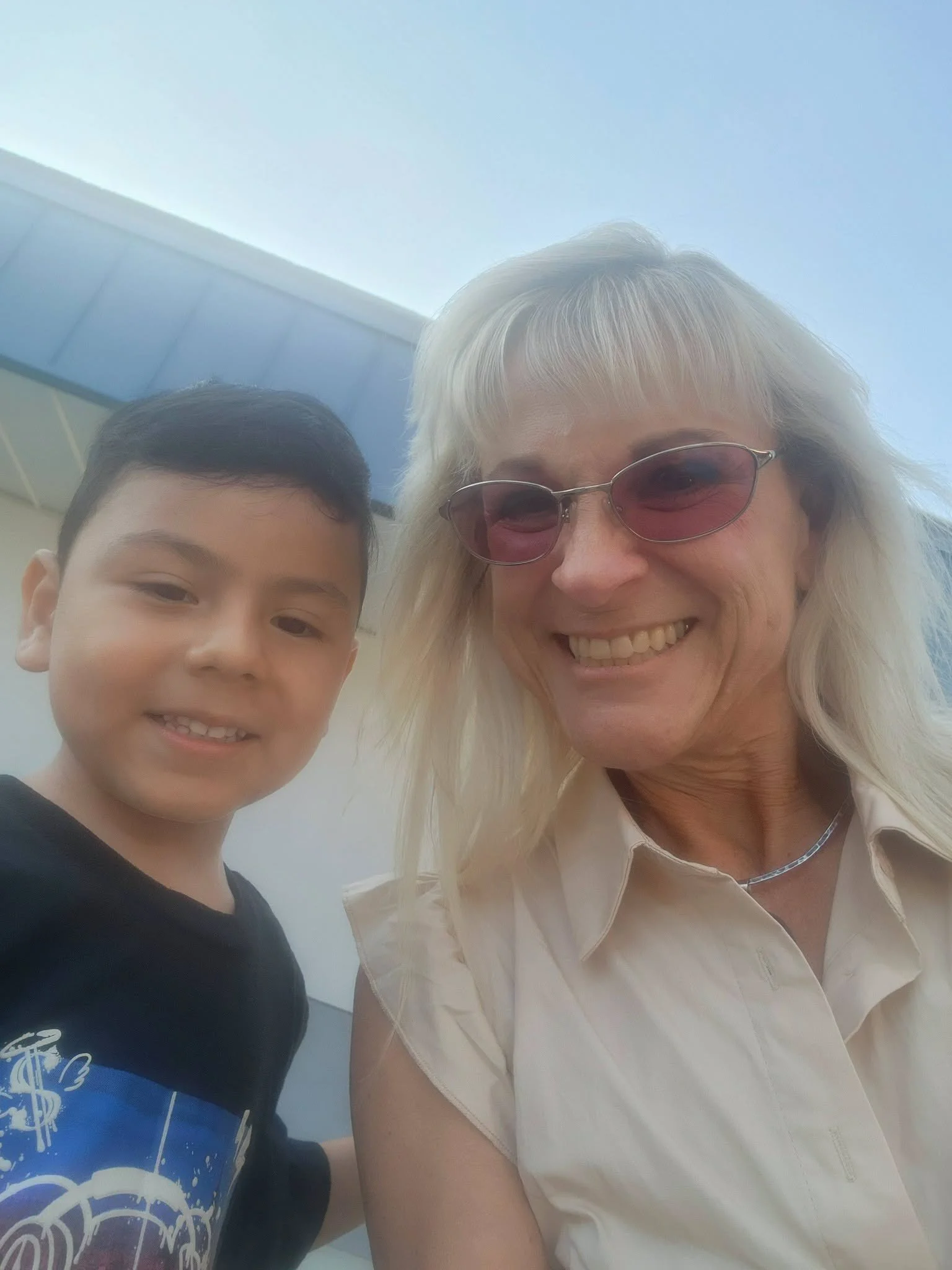 A young student and school staff member pose for a welcome-event photo.