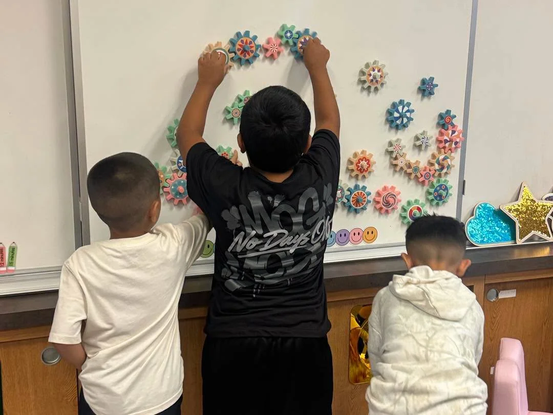 Students arrange colorful gears on a board during the tour.
