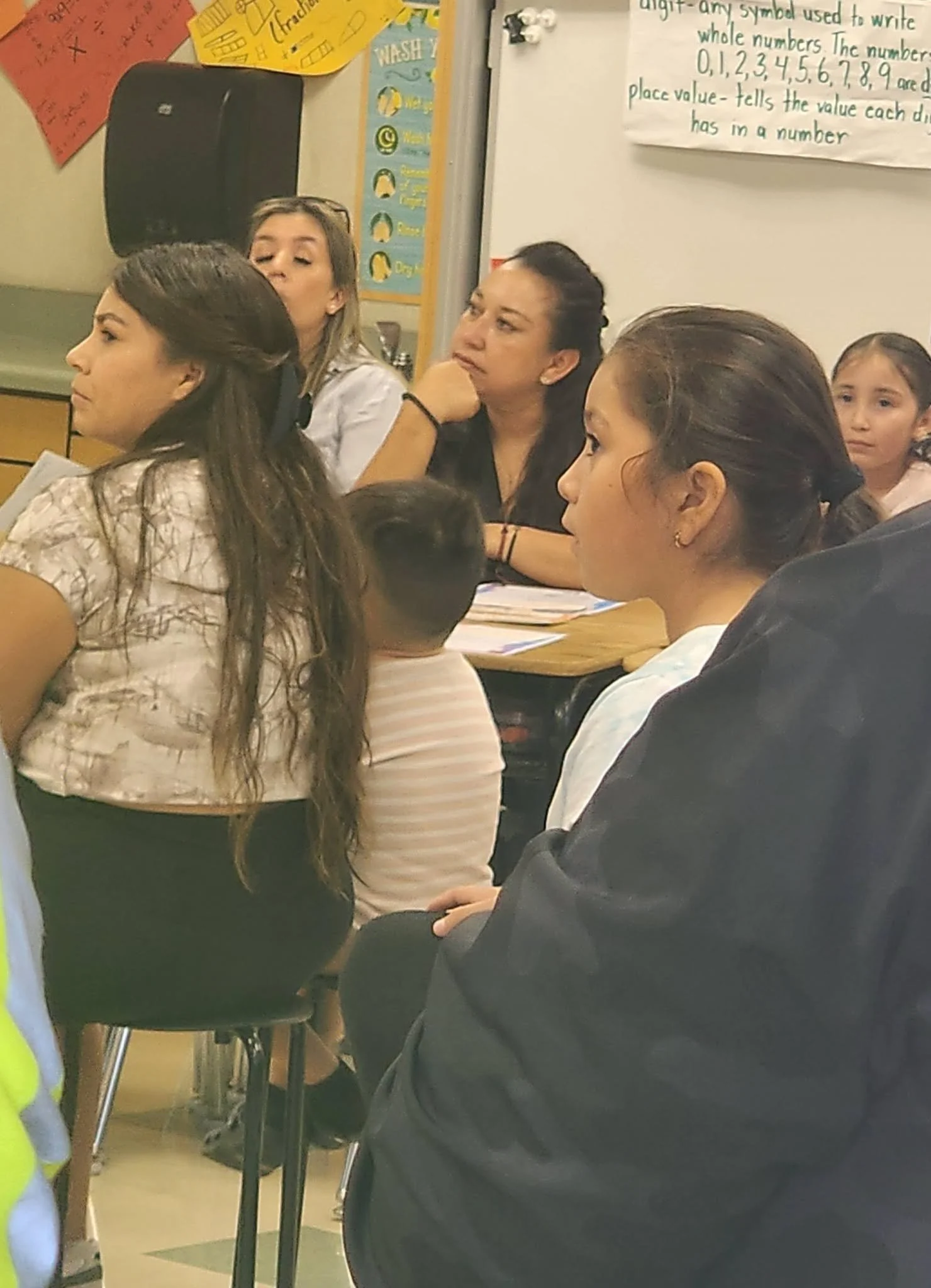 Wildcat family members listen during a classroom visit at Back to School Night.