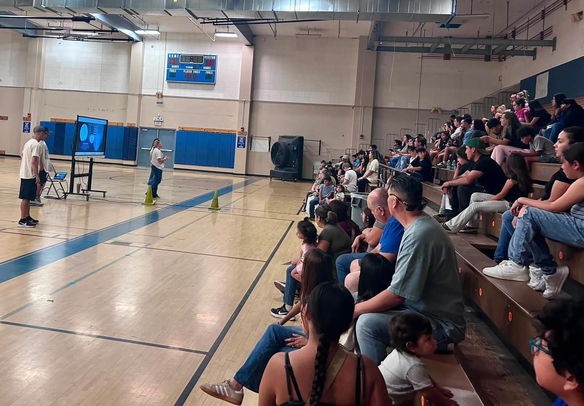 Bulldog families listen to a presentation in the Fillmore Middle School gym.
