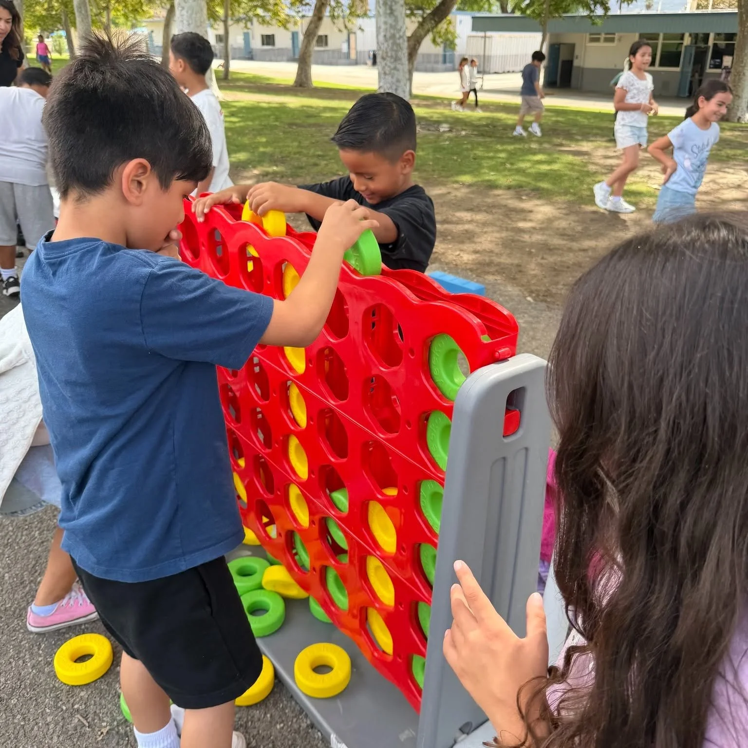 Students play a giant Connect Four game outdoors during Recess Fest.