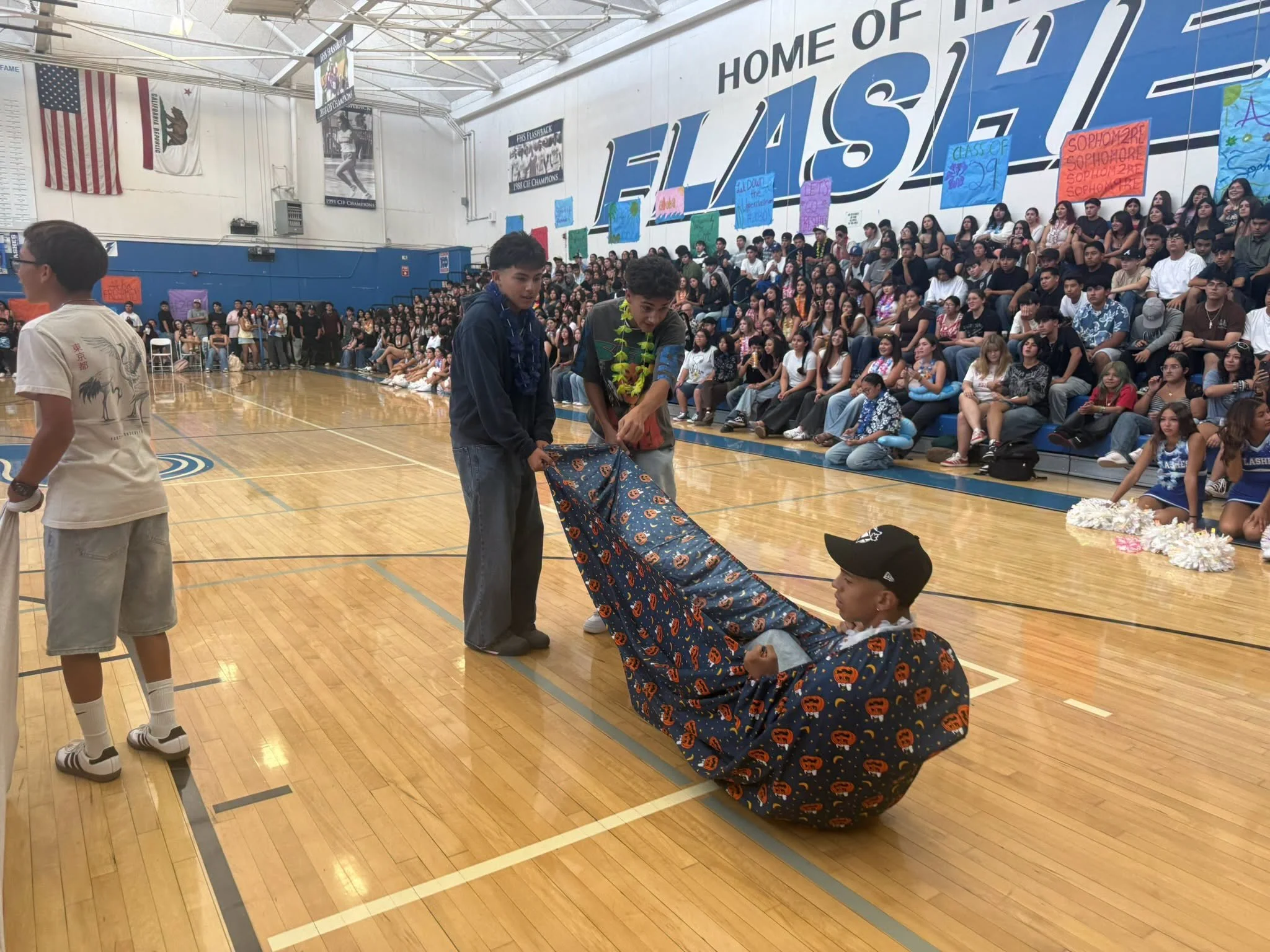 Students participate in a blanket race during a school assembly in the Flashes gym.