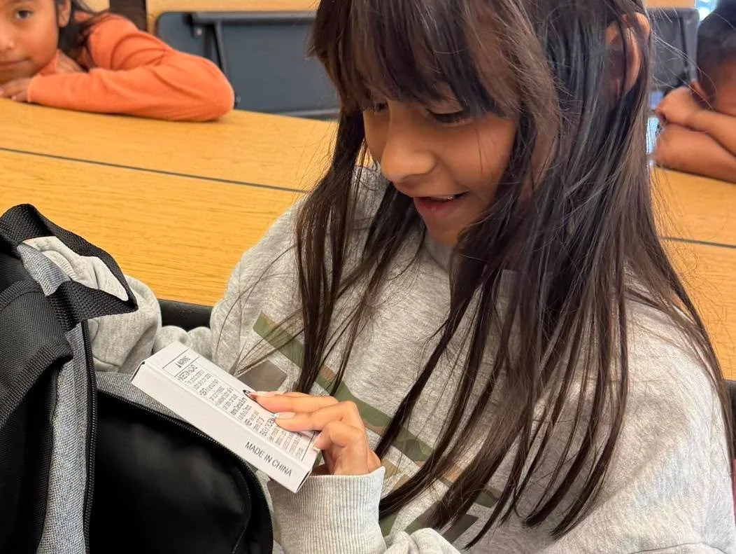 A student explores supplies inside a donated backpack.