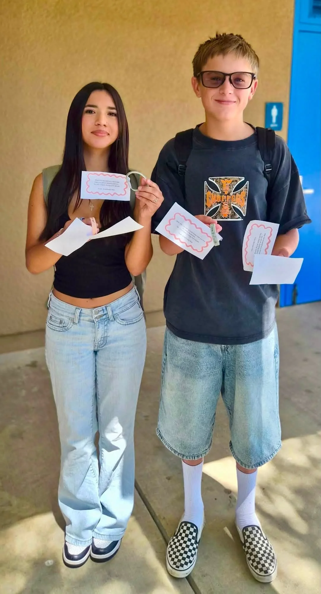 Two FMS Wellness Peers hold affirmation cards and kindness bracelets.