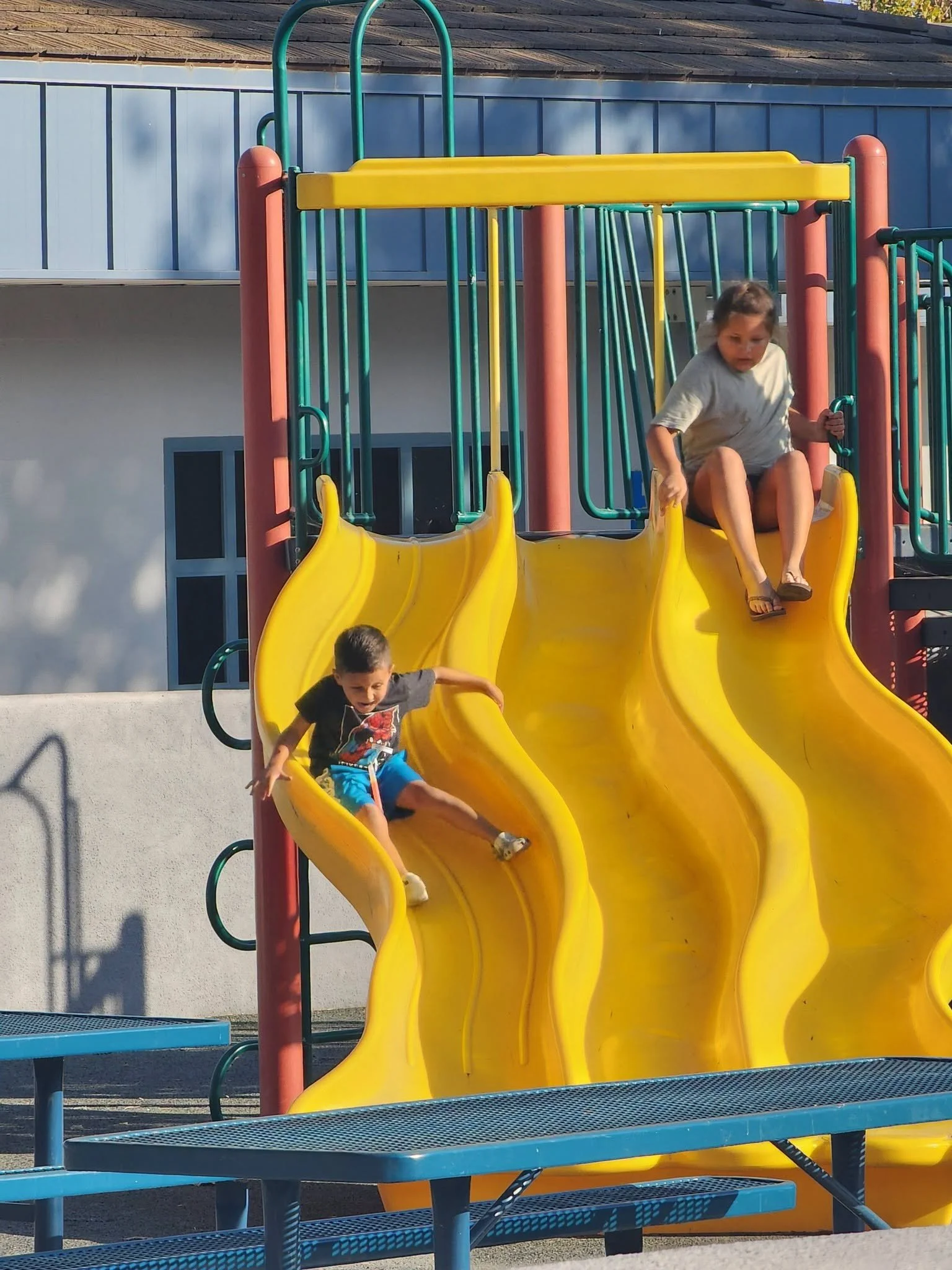 Children enjoy the yellow playground slides during the welcome event.
