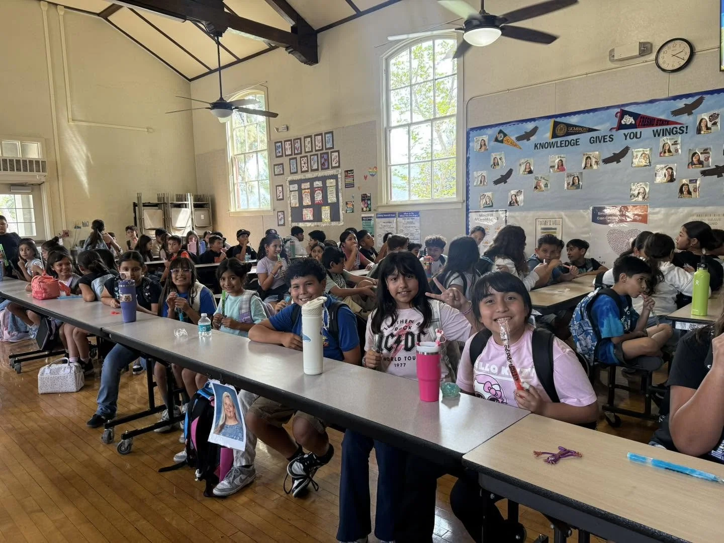 Piru students sit at cafeteria tables and enjoy Otter Pops during an attendance celebration.