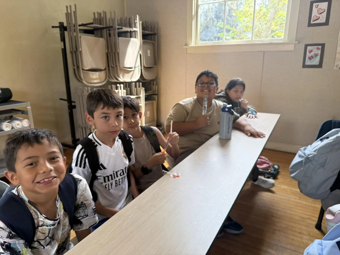 Piru students sit at a cafeteria table and enjoy cool treats during an attendance celebration.