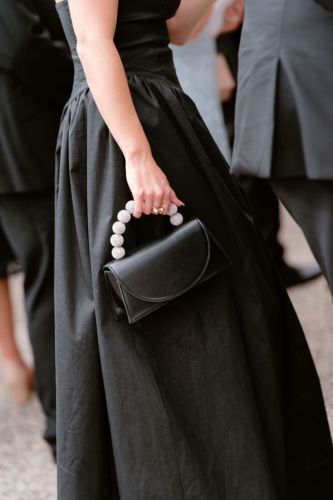 A woman wearing a black dress holding a black handbag with a pearl handle at a formal event. Hunter Valley wedding photographer couple portrait
Bowral wedding cinematography vineyard film still
Newcastle wedding candid moment natural storytelling