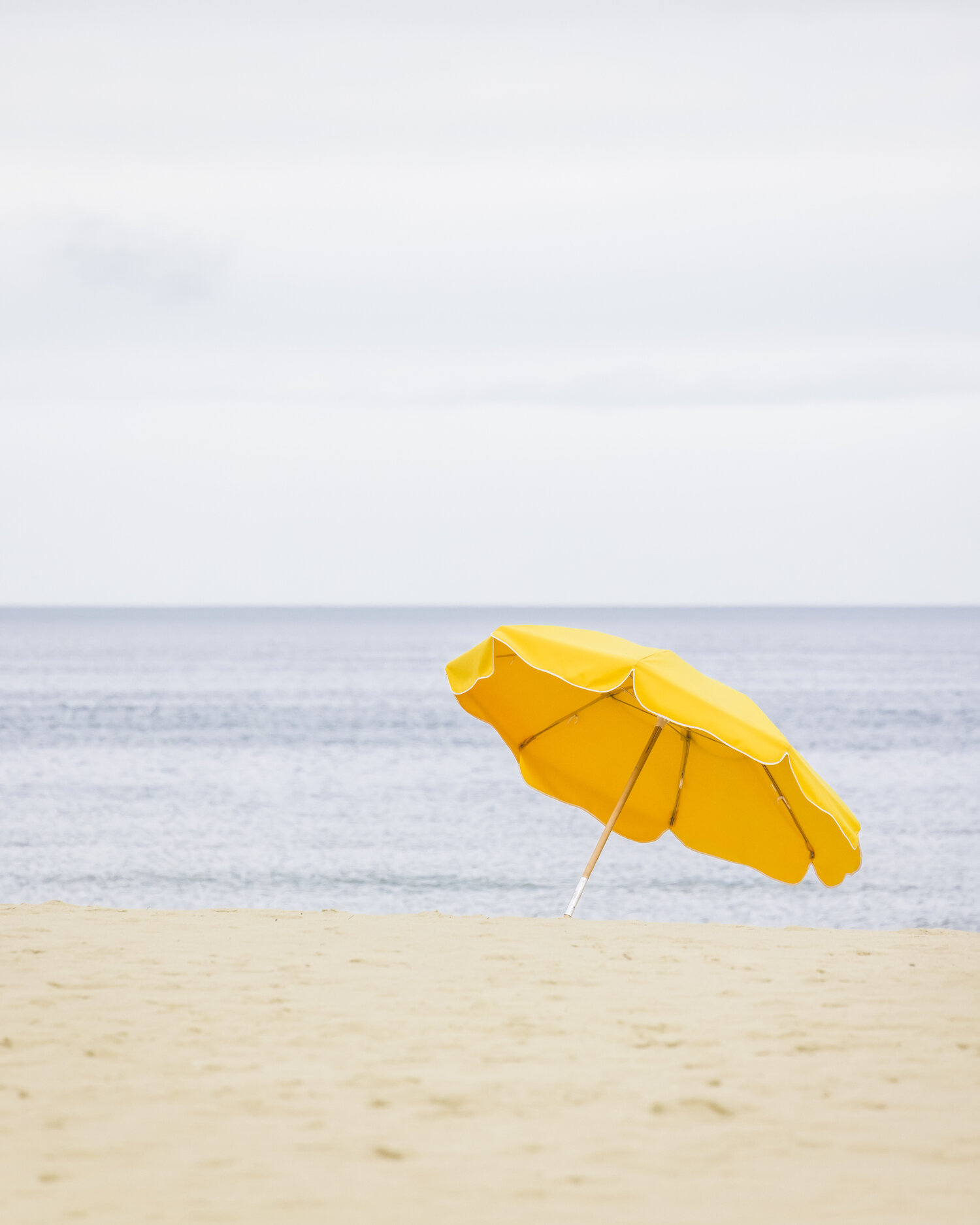 Yellow beach umbrella with the Nantucket ocean