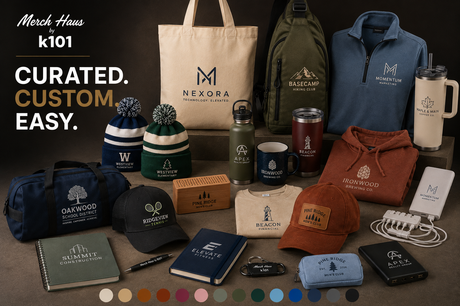 An assortment of branded merchandise including clothing, drinkware, accessories, and promotional items displayed on a table. Items feature logos for companies such as Nexora, Momentum Marketing, Maple & Main Coffee Co., Westview Elementary, Oakwood School District, Ridgeview Tennis, Summit Construction, Elevate Fitness, and Pine Ridge Men’s Club.