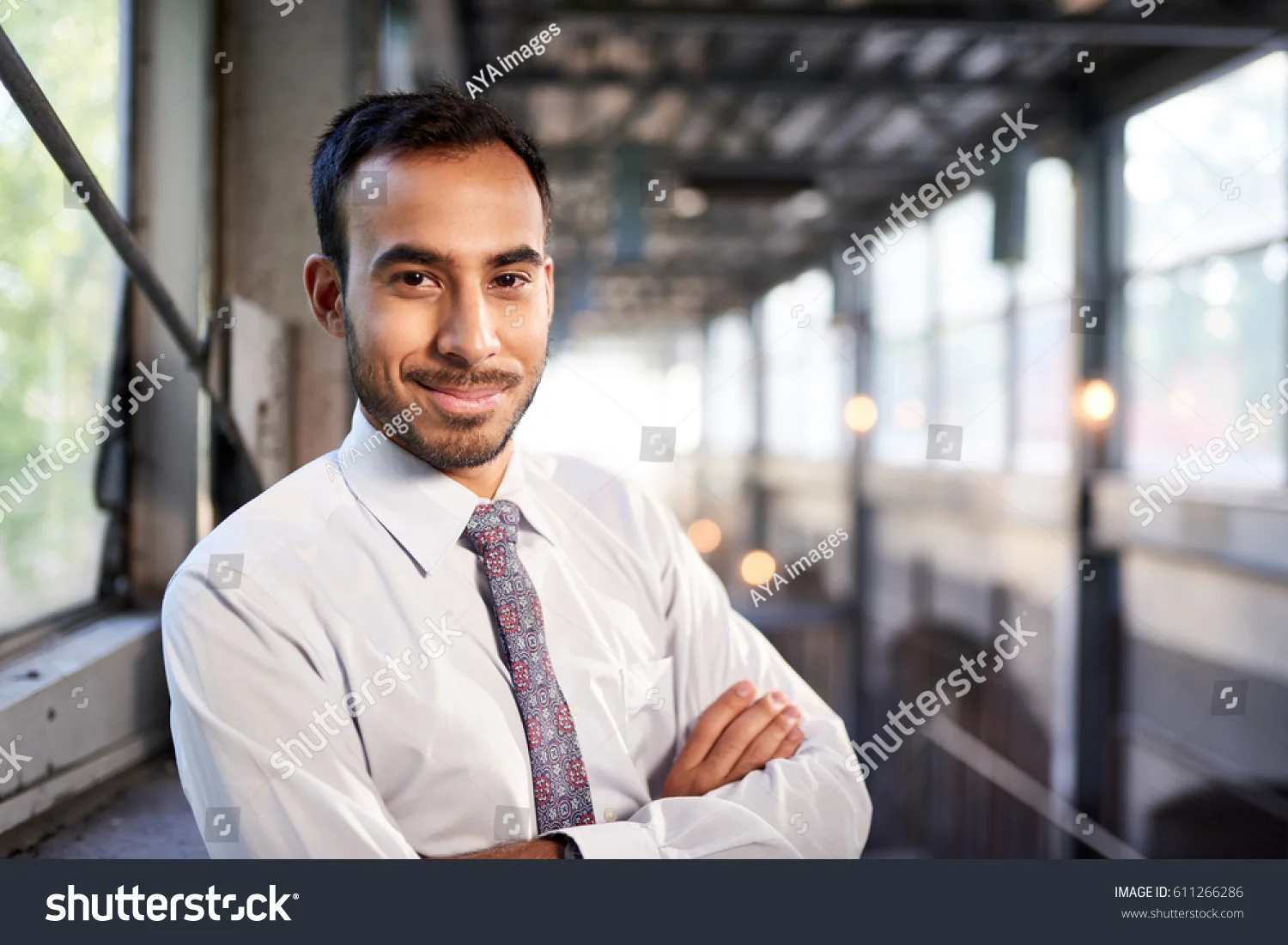 stock-photo-indian-businessman-smiling-confidently-with-cityscape-background-611266286.jpg
