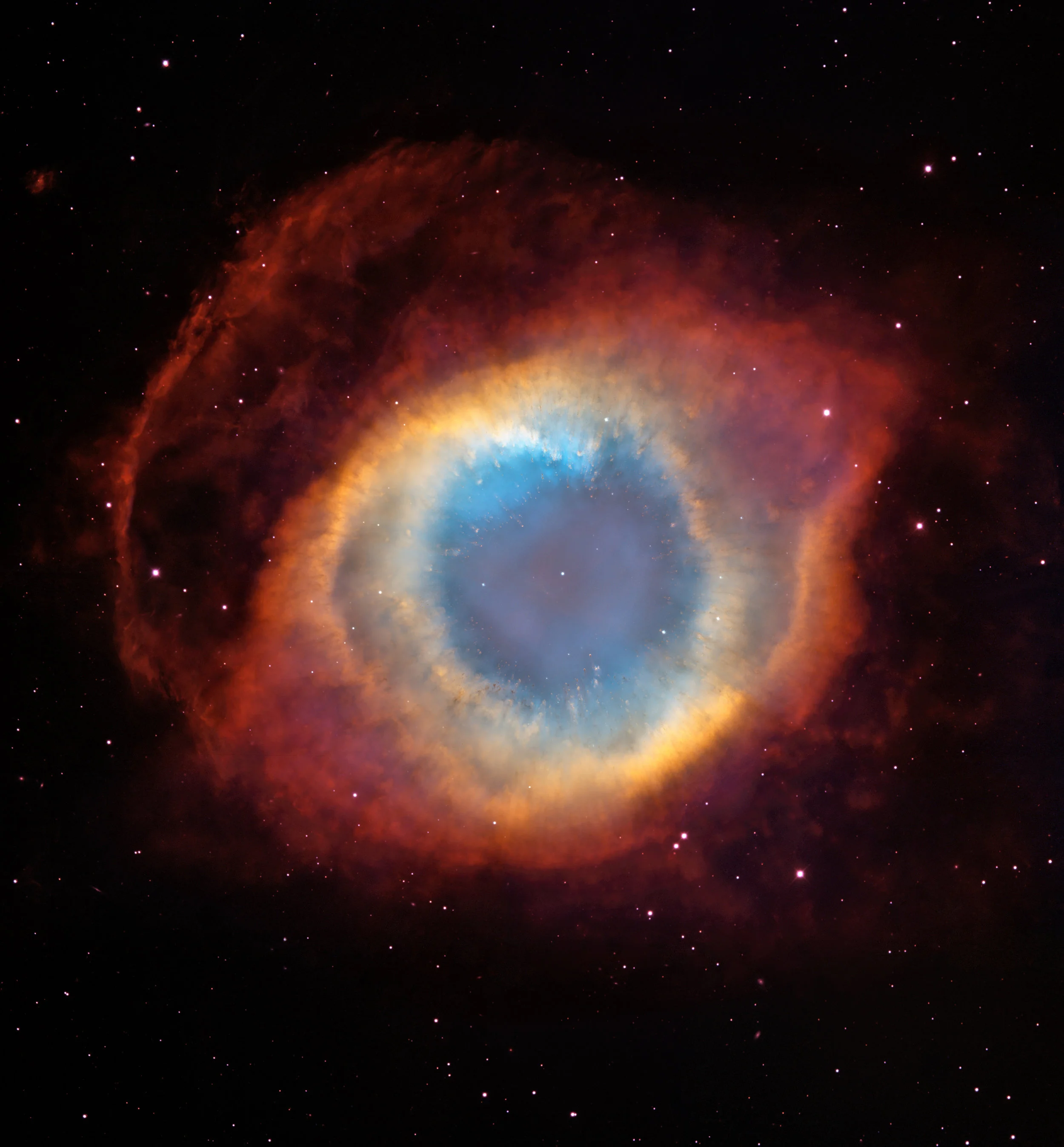 This composite image is a view of the colorful Helix Nebula taken with the Advanced Camera for Surveys aboard NASA / ESA Hubble Space Telescope and the Mosaic II Camera on the 4-meter telescope at Cerro Tololo Inter-American Observatory in Chile. The object is so large that both telescopes were needed to capture a complete view. The Helix is a planetary nebula, the glowing gaseous envelope expelled by a dying, sun-like star. The Helix resembles a simple doughnut as seen from Earth. But looks can be deceiving. New evidence suggests that the Helix consists of two gaseous disks nearly perpendicular to each other. Credit: NASA , ESA , C.R. O'Dell (Vanderbilt University), and M. Meixner, P. McCullough, and G. Bacon ( Space Telescope Science Institute )