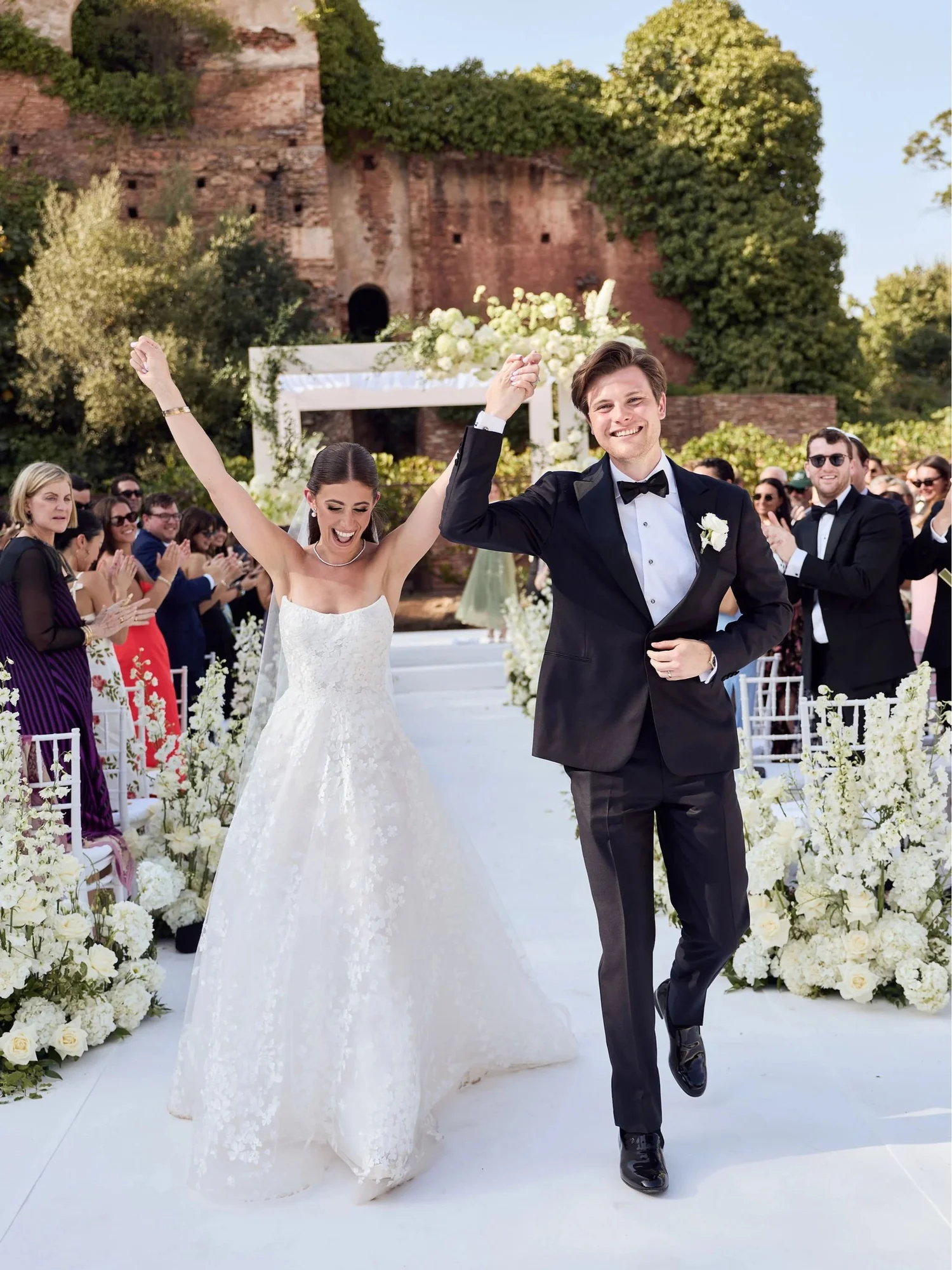 Newlyweds celebrating with raised hands after their wedding ceremony