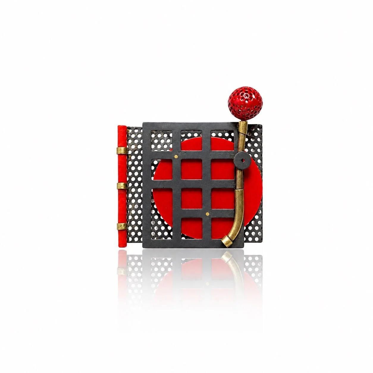 Behind the Red Grid

A red form sits behind a rigid black grid&mdash;partly hidden, but never completely.

Made from perforated steel, brass, acrylic and found mechanical elements, this brooch considers walls as structures that protect, divide and ho