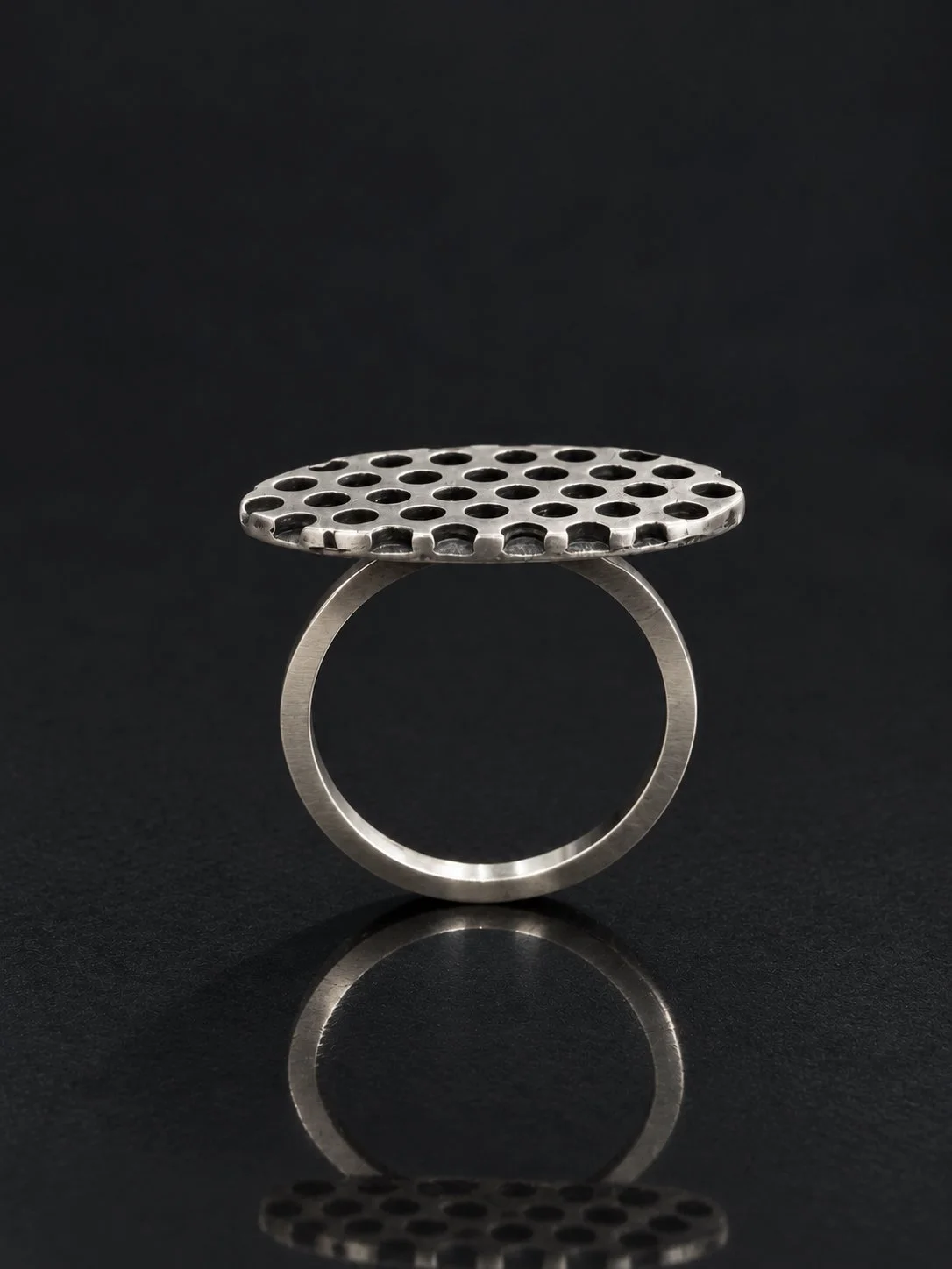Perforated Silver Ring on Charcoal Surface.jpg
