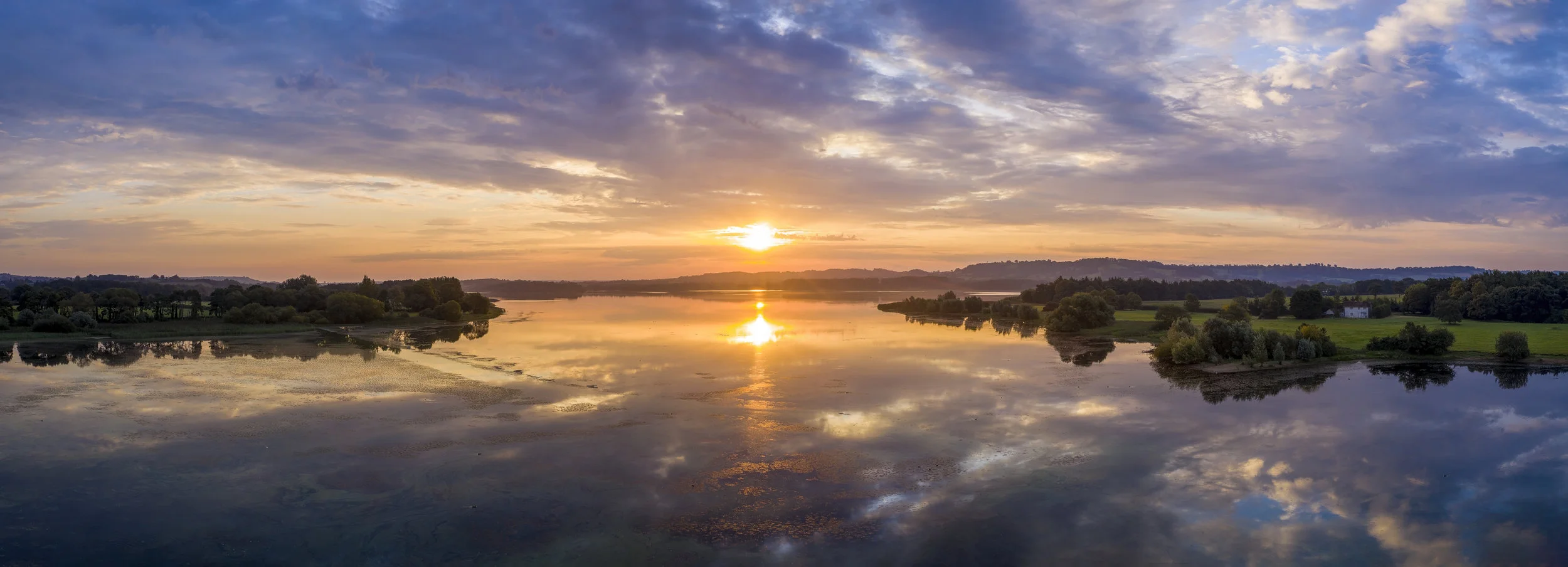 Horizontal panoramic sunrise of Chew Valley Lake.