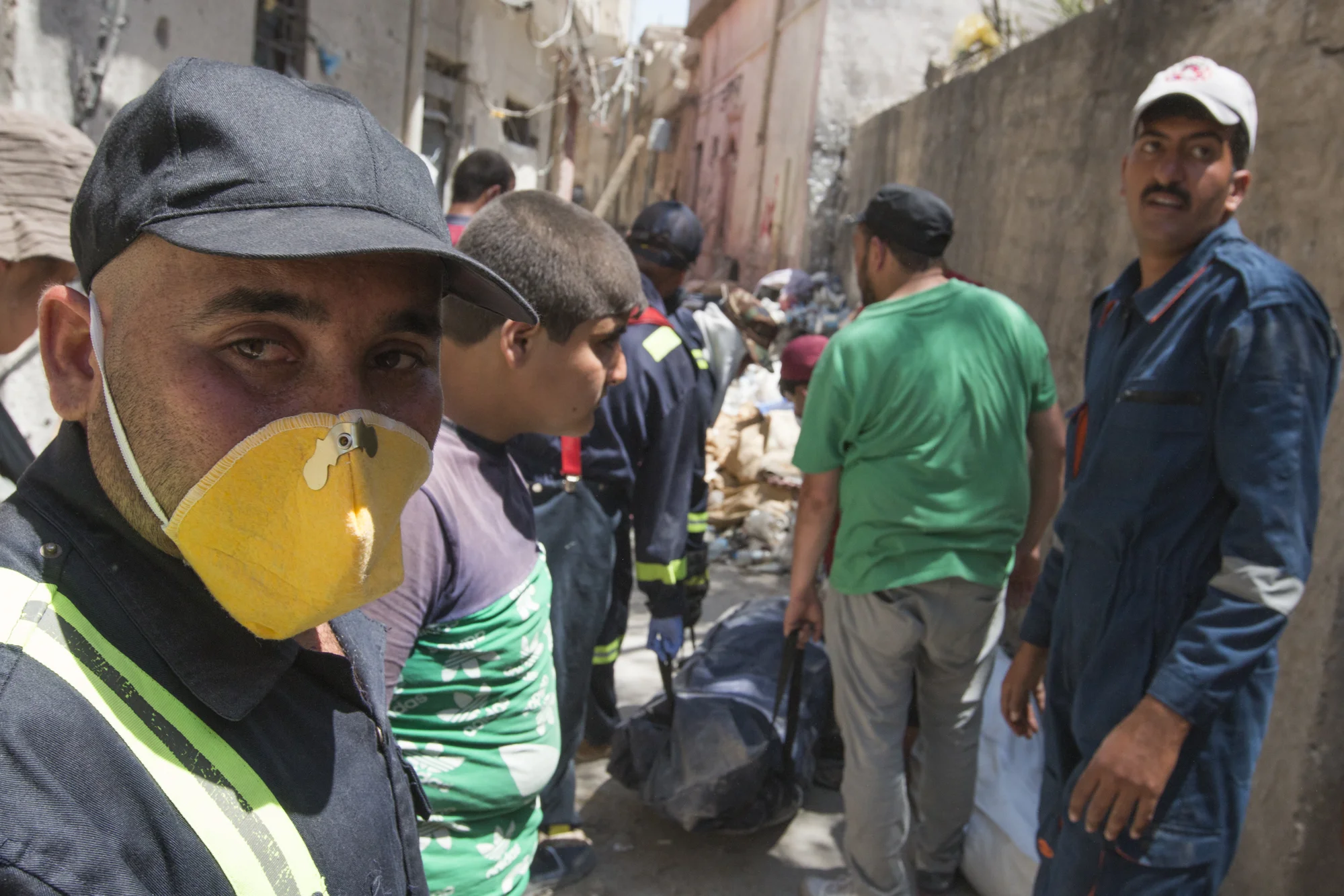 Civil defense force members prepare to make their way out of the Old City after recovering the remains of Noor Ganem and Nectar Wadala