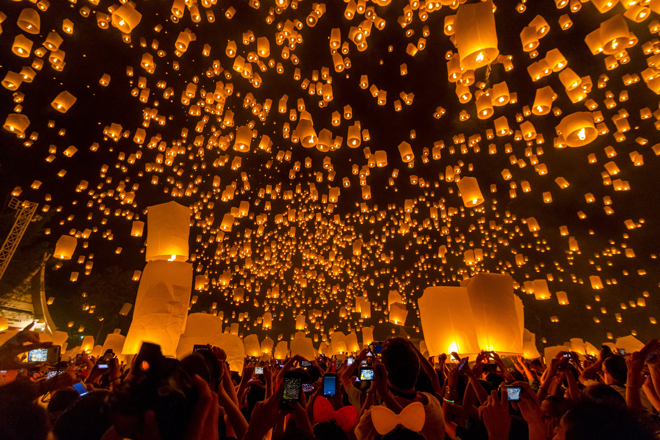 Large numbers of paper lanterns are released as people take pictures during the yi ping ceremony, part of the festivities celebrating the Loi Kratom holiday in Chiang Mai, Thailand - November 2013.