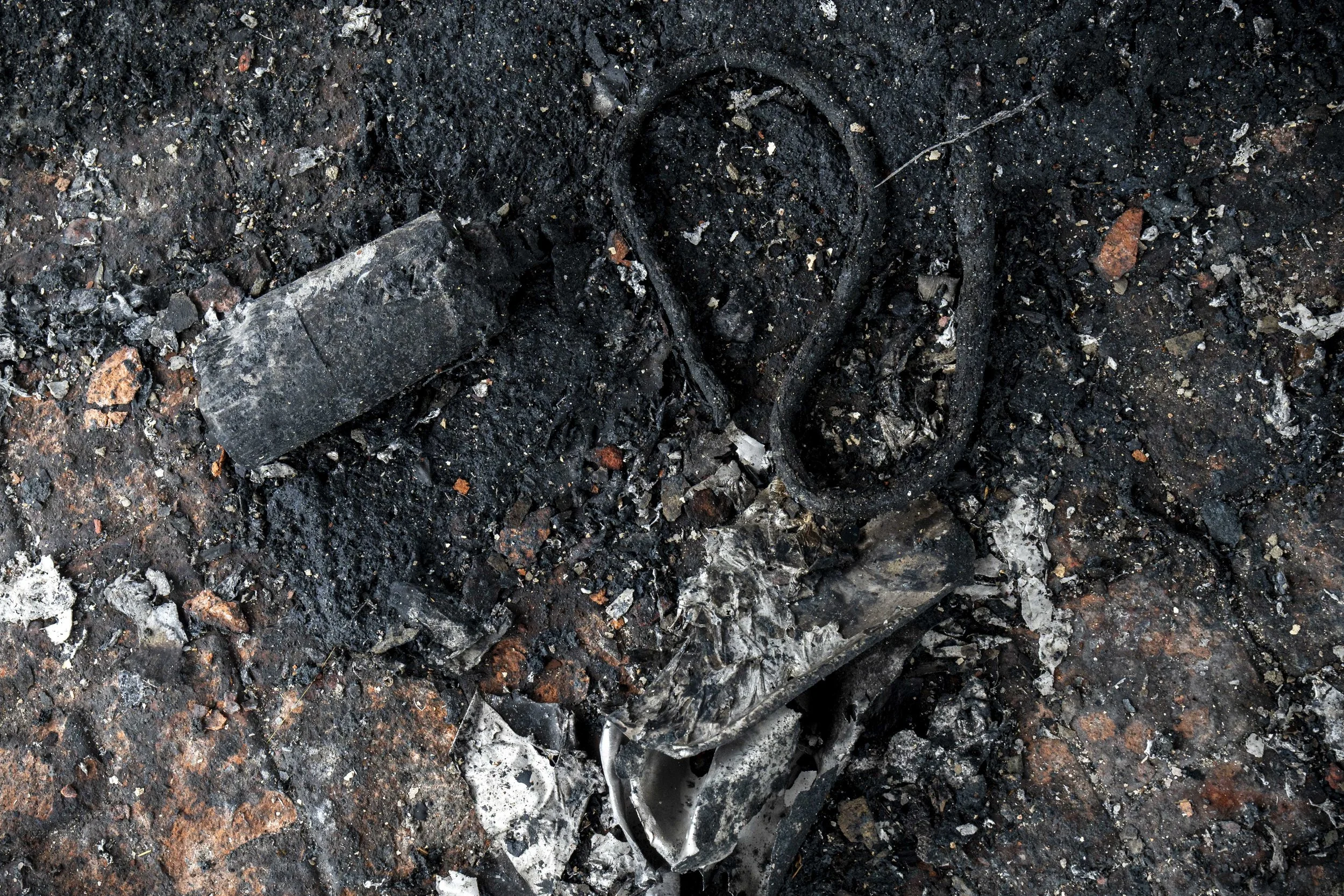 Burned debris lays on the ground outside of the 7-11 convenience store in Ban Phue, Sisaket Province which was hit by Cambodian munitions, as seen on July 27th, 2025. 8 people, including 2 school children, were killed and several injured by the stri