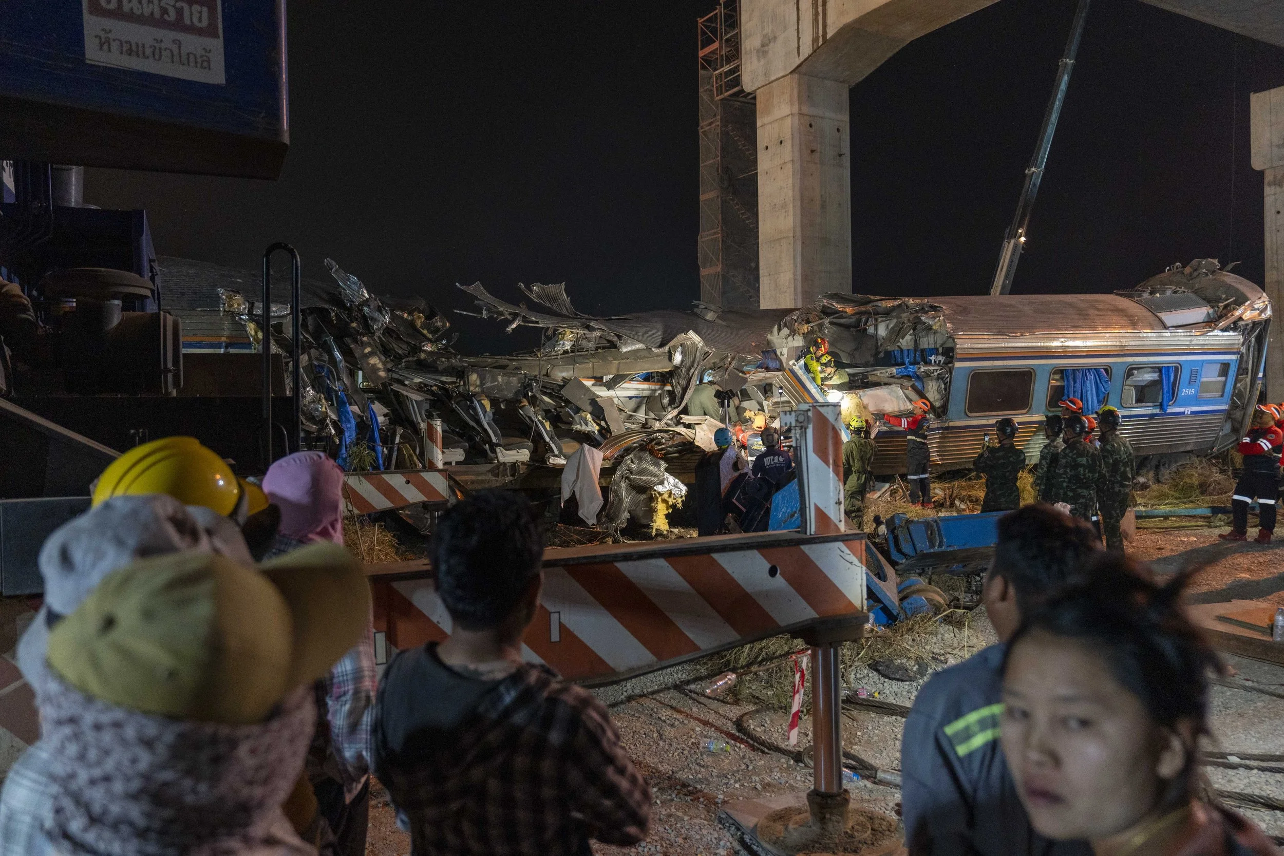  January 14, 2026: Search and rescue workers inspect a heavily damaged train car which was crushed by a falling crane while the train was was moving underneath the Thai-Chinese high speed rail construction site, approximately 12 hours after the disas