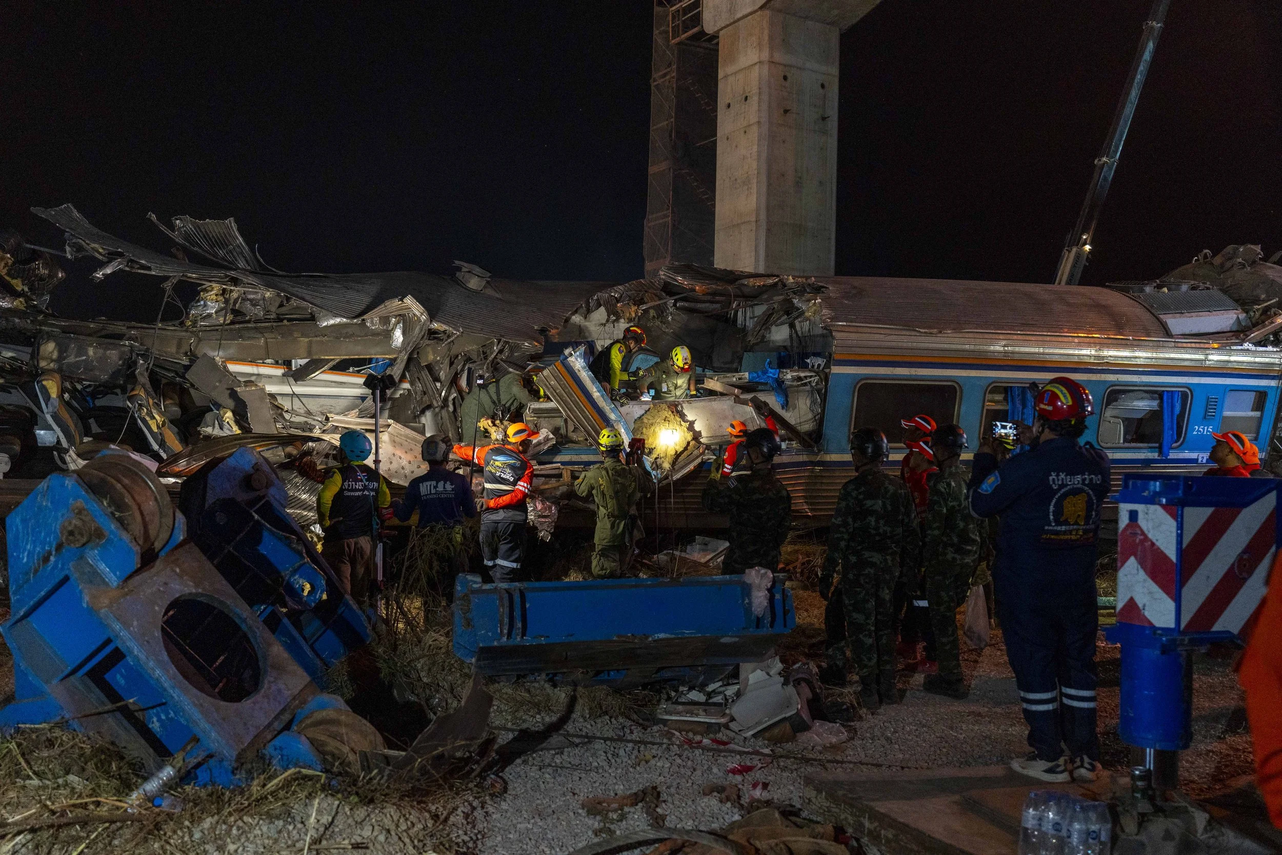  January 14, 2026: Search and rescue workers inspect a heavily damaged train car which was crushed by a falling crane while the train was was moving underneath the Thai-Chinese high speed rail construction site, approximately 12 hours after the disas