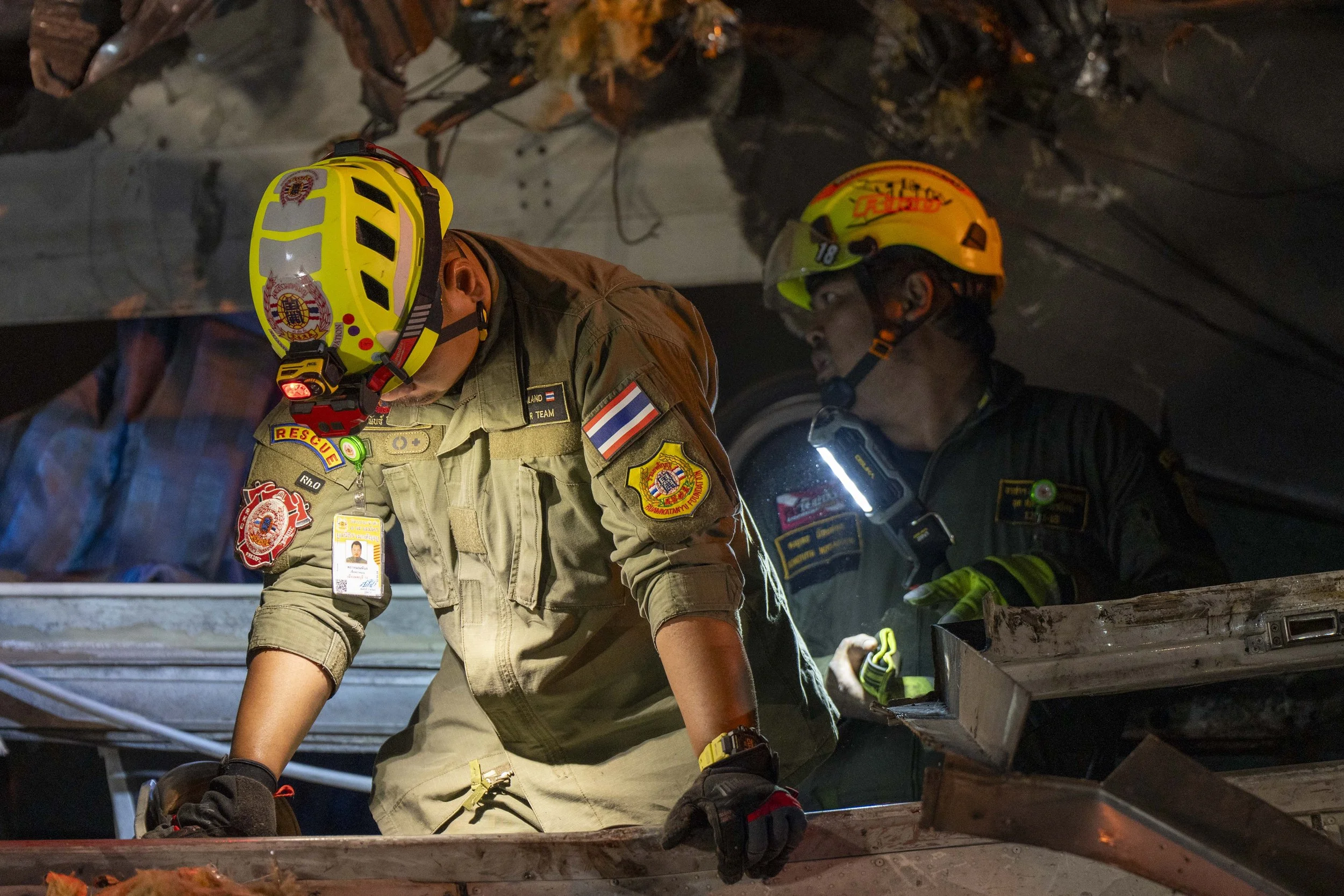  January 14, 2026: Search and rescue workers inspect a heavily damaged train car which was crushed by a falling crane while the train was was moving underneath the Thai-Chinese high speed rail construction site, approximately 12 hours after the disas