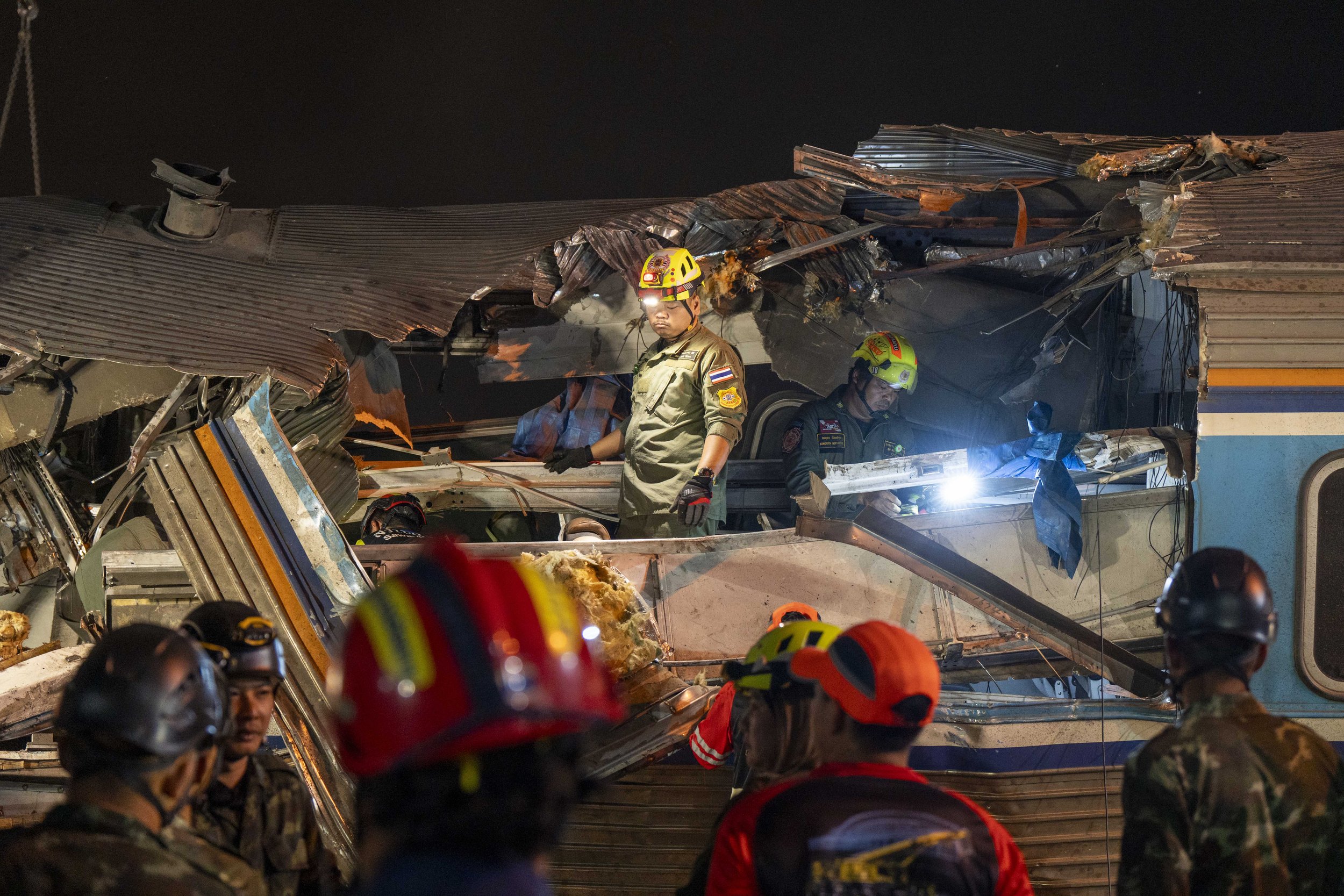  January 14, 2026: Search and rescue workers inspect a heavily damaged train car which was crushed by a falling crane while the train was was moving underneath the Thai-Chinese high speed rail construction site, approximately 12 hours after the disas