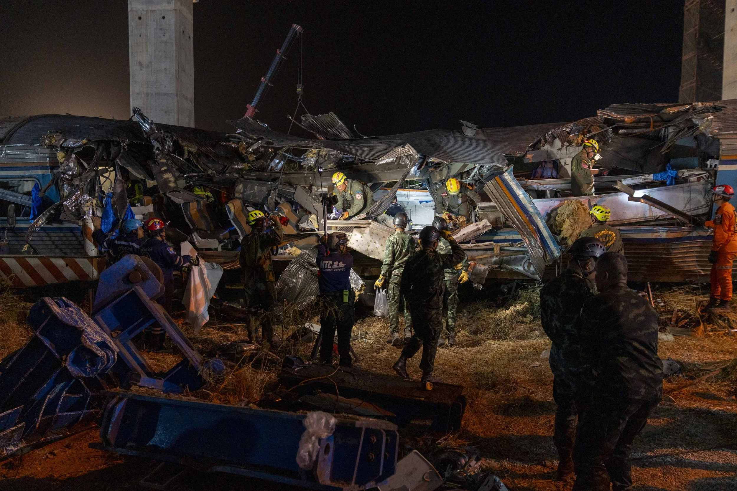  January 14, 2026: Search and rescue workers inspect a heavily damaged train car which was crushed by a falling crane while the train was was moving underneath the Thai-Chinese high speed rail construction site, approximately 12 hours after the disas