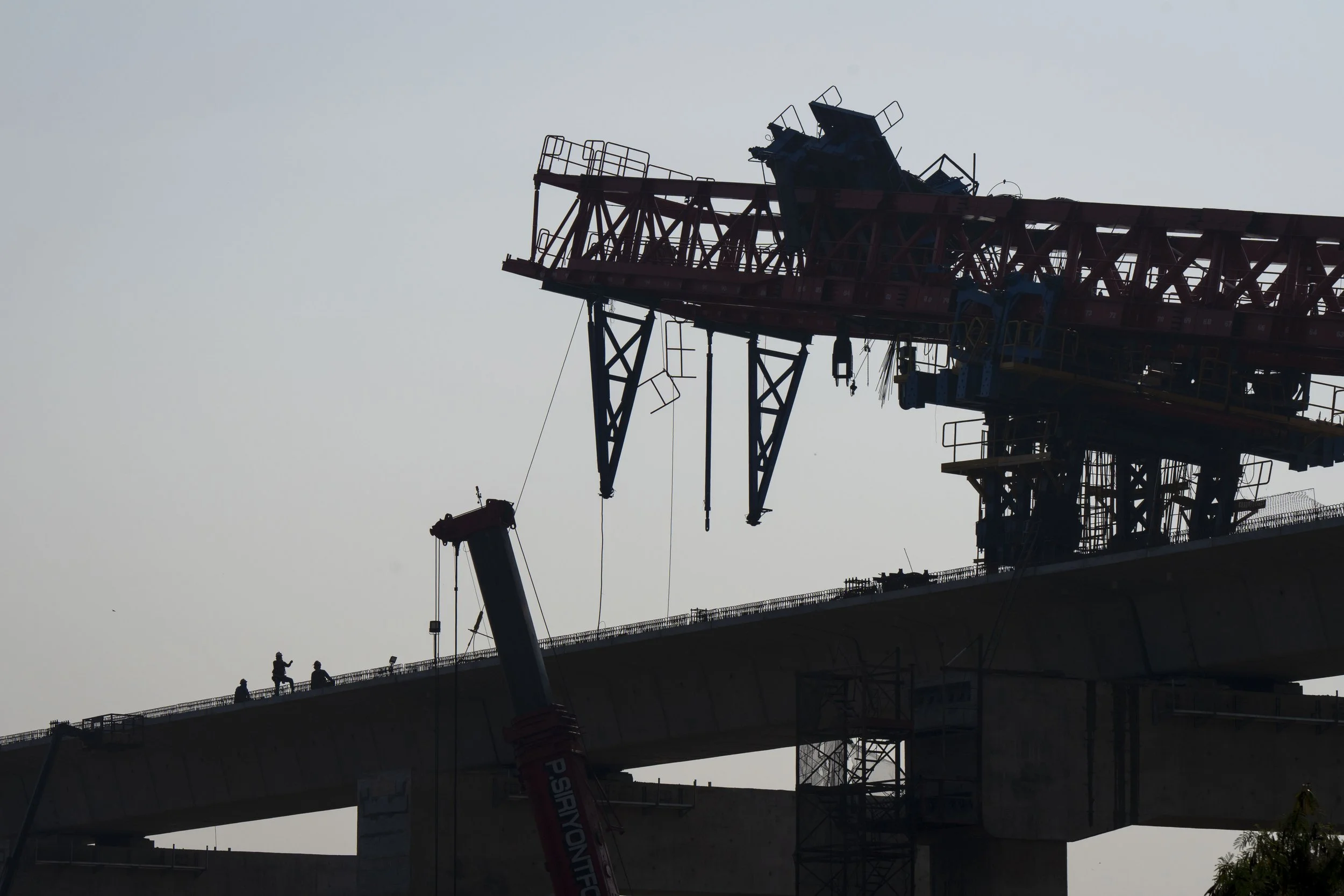  January 15, 2026: Construction workers stand on the partially completed Thai - Chinese elevated rail line and inspect a large crane which collapsed the previous day onto a moving train that was traveling at ground level, claiming 32 lives - for Anad