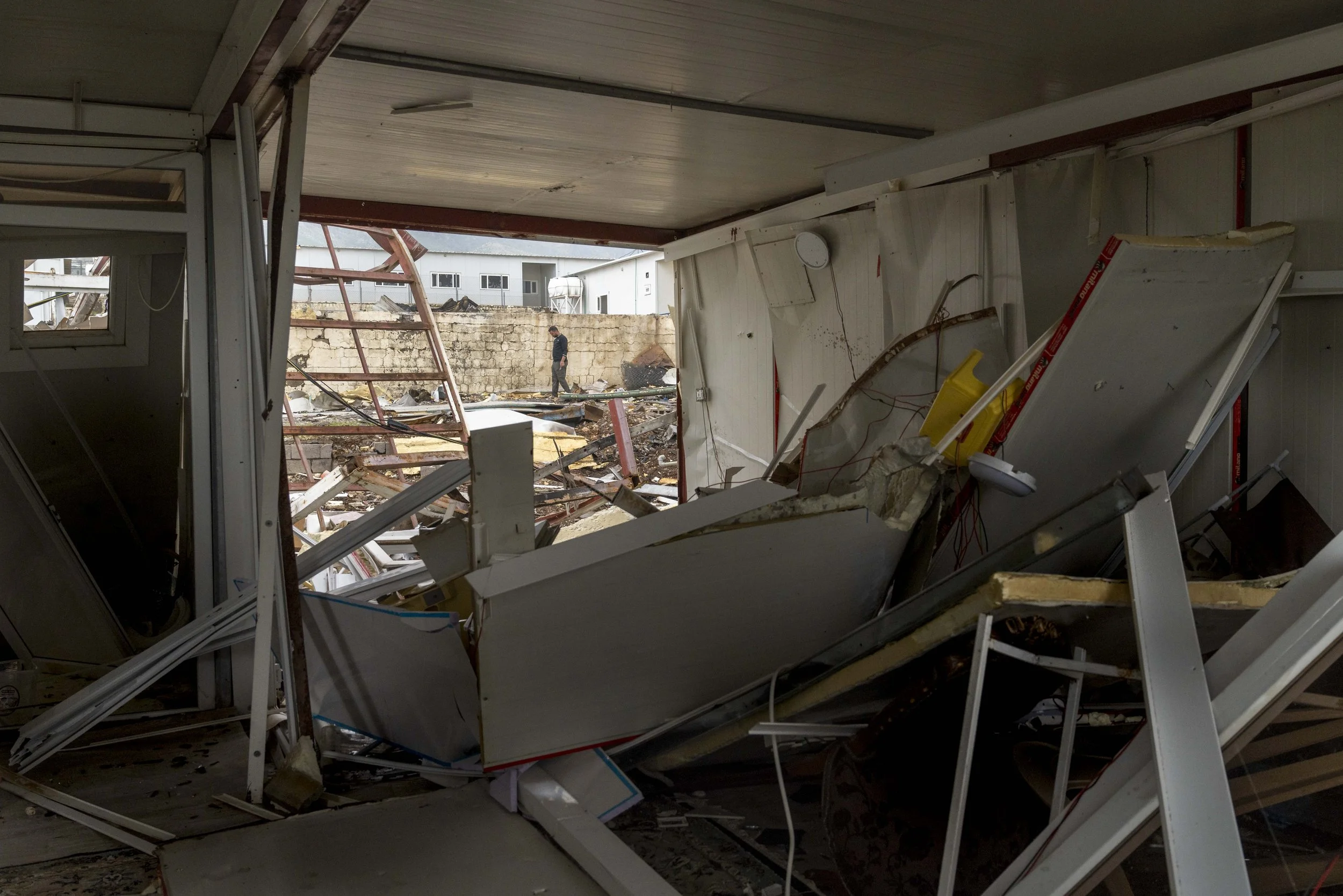  A Komala member walks pat a destroyed section of the Surdash  camp which was obliterated by the April 14 Iranian shahed drone attack. 