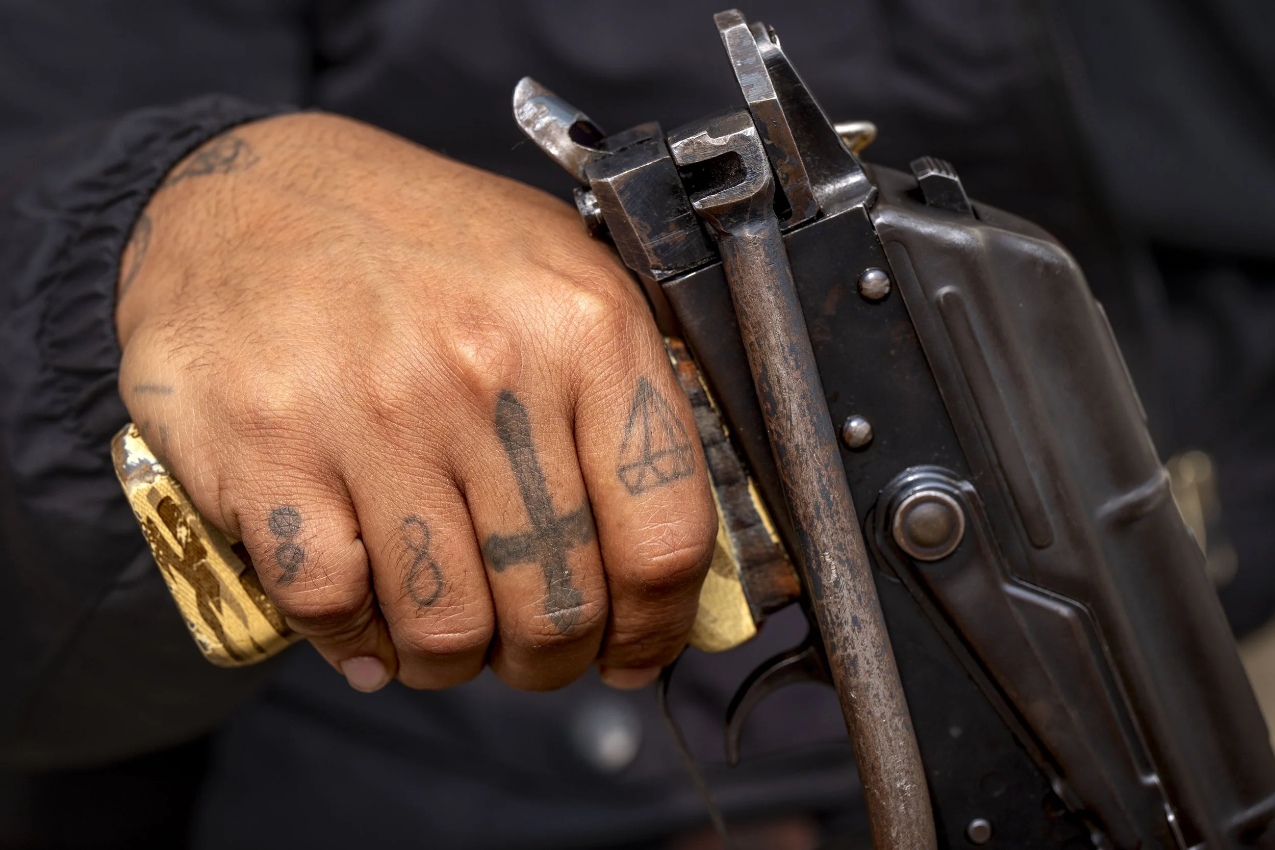  A Komala fighter’s tattooed hand grips an AK 47 rifle. 